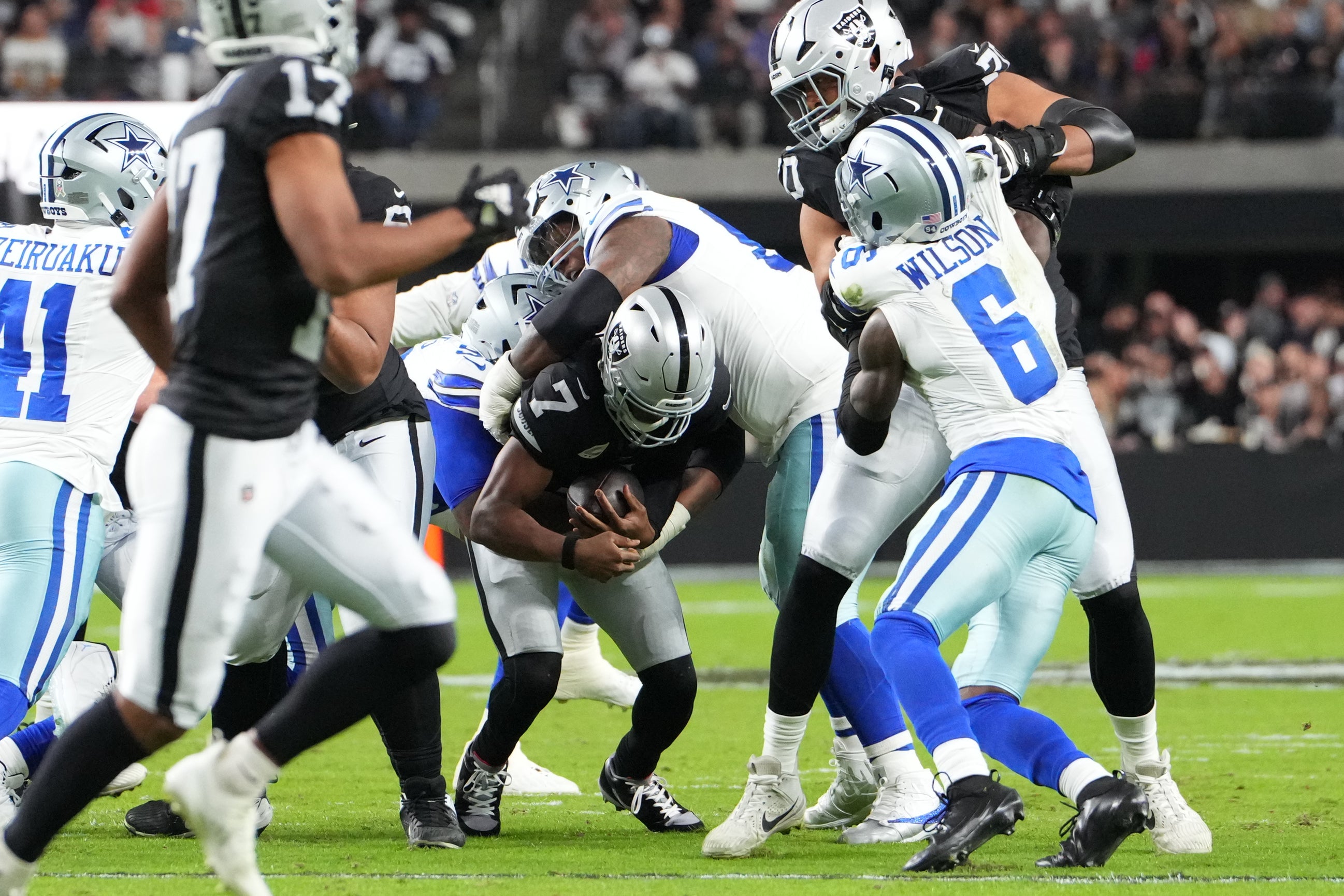 Nov 17, 2025; Paradise, Nevada, USA; Las Vegas Raiders quarterback Geno Smith (7) is sacked by Dallas Cowboys defensive tackle Kenny Clark (95) and defensive tackle Quinnen Williams (92) during the first half at Allegiant Stadium.
