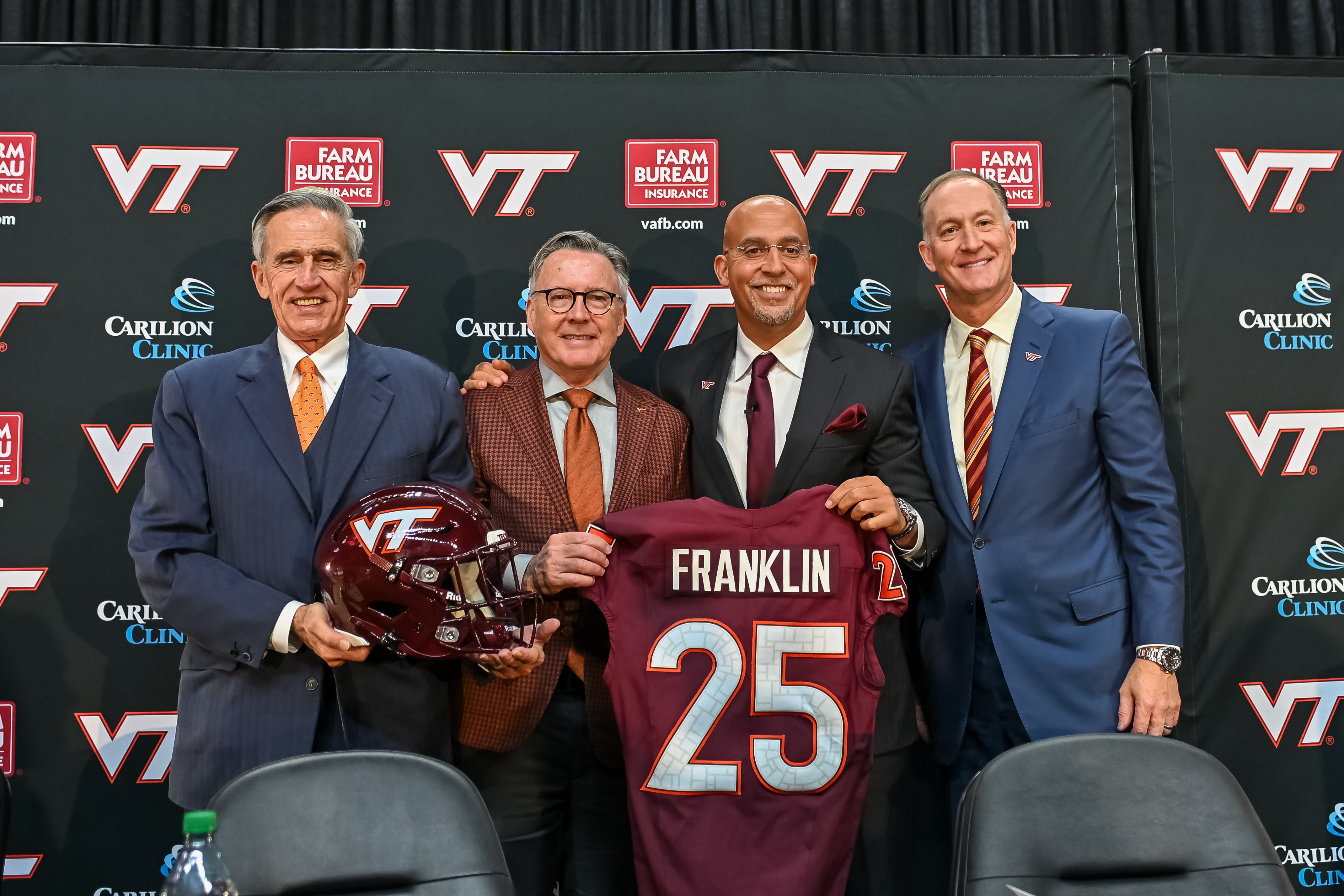 Nov 19, 2025; Blacksburg, VA, USA; L-R, John Rocovich, Timothy Sands, James Franklin and Whit Babcock hold up a Virginia Tech jersey during the press conference celebrating Franklin as head coach at Cassell Coliseum. Mandatory Credit: Brian Bishop-Imagn Images