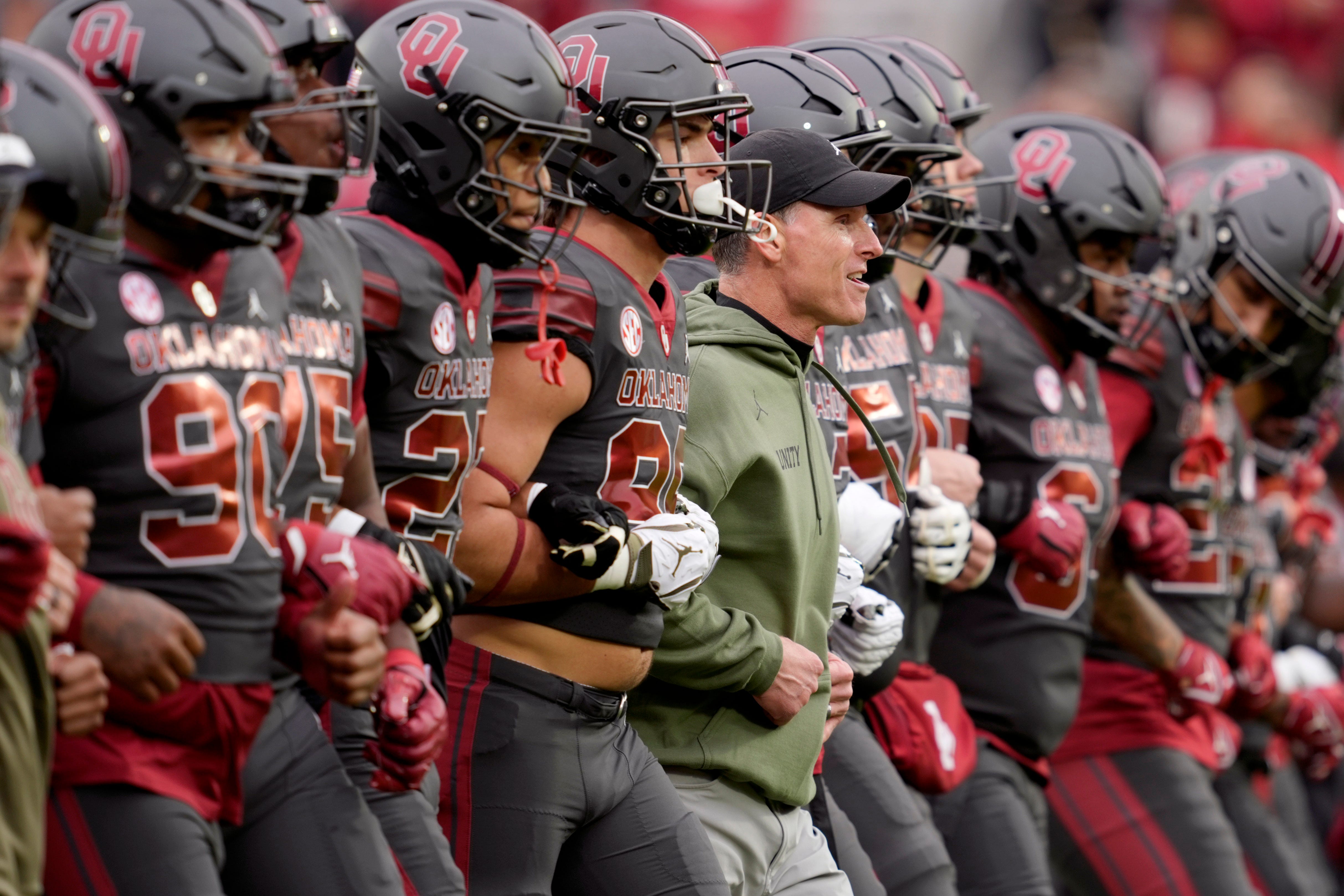 Oklahoma coach Brent Venables locks arms with players before a college football game between the University of Oklahoma Sooners (OU) and the Missouri Tigers at Gaylord Family Ð Oklahoma Memorial Stadium in Norman, Okla., on Saturday, Nov. 22, 2025. Oklahoma won 17-6.