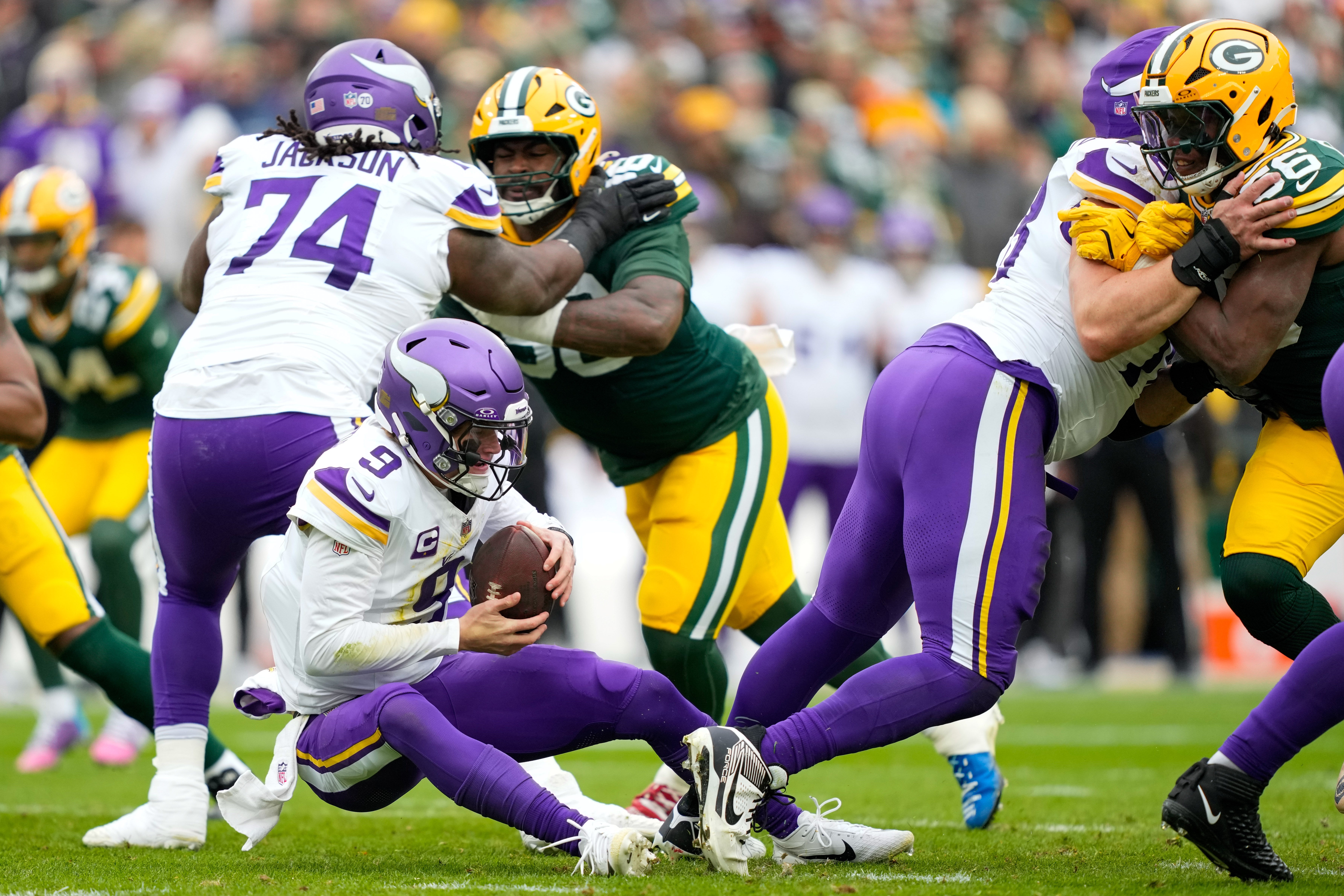 Nov 23, 2025; Green Bay, Wisconsin, USA; Minnesota Vikings quarterback J.J. McCarthy (9) recovers his own fumble during the first half against the Green Bay Packers at Lambeau Field.