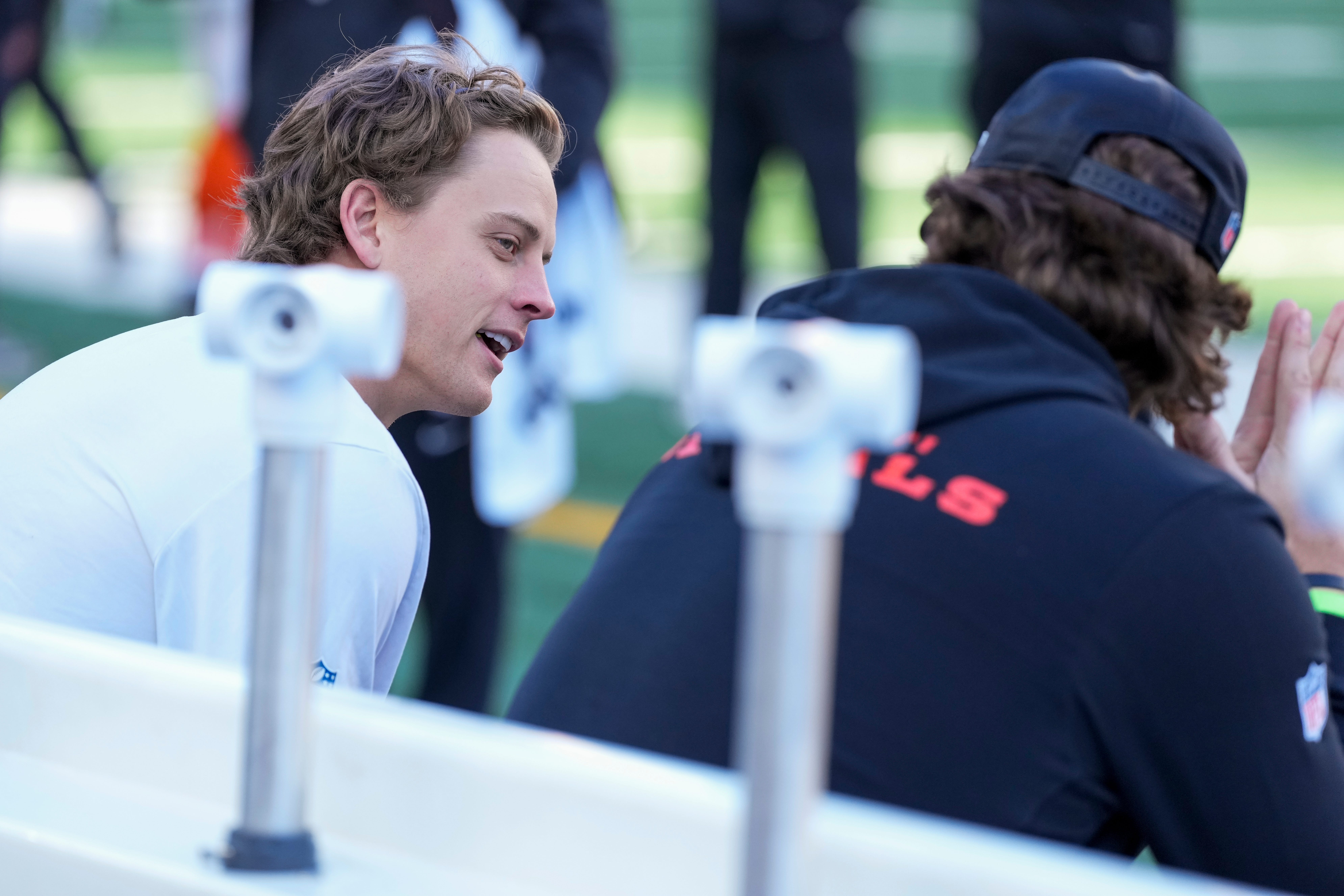Injured Cincinnati Bengals quarterback Joe Burrow (9) talks on the bench with injured defensive end Trey Hendrickson (91) in the second quarter of the NFL Week 12 game between the Cincinnati Bengals and the New England Patriots at Paycor Stadium in downtown Cincinnati on Sunday, Nov. 23, 2025.
