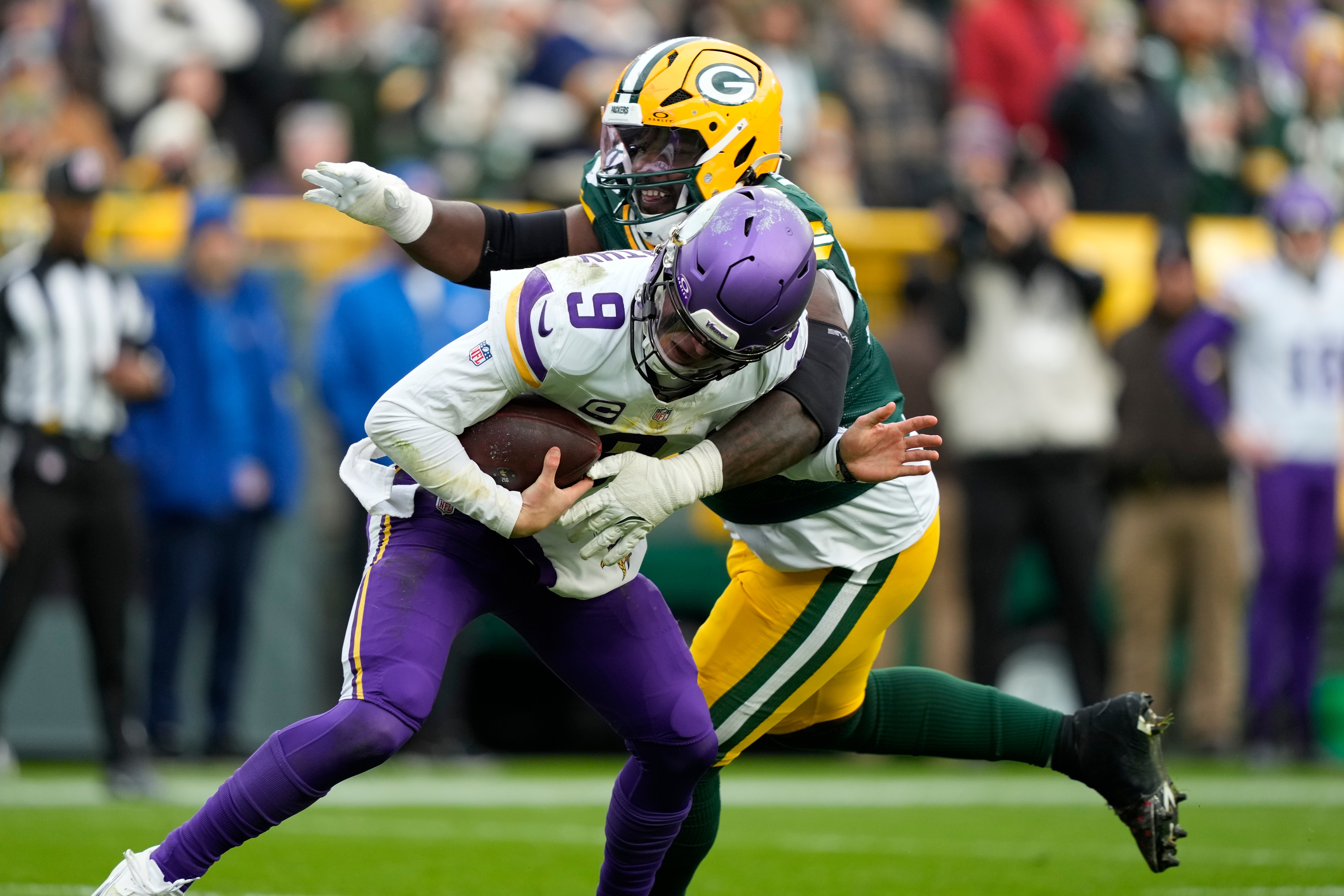 Nov 23, 2025; Green Bay, Wisconsin, USA; Minnesota Vikings quarterback J.J. McCarthy (9) is sacked by. Green Bay Packers defensive tackle Devonte Wyatt (95) during the second half at Lambeau Field.