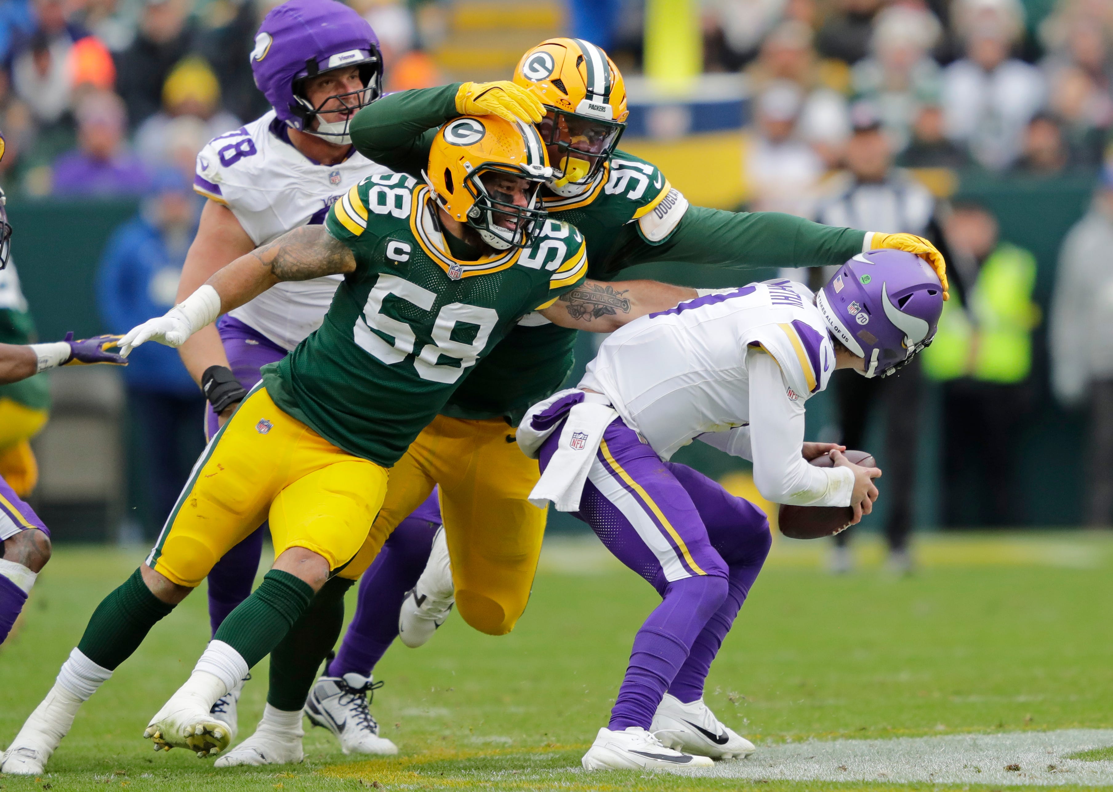 Green Bay Packers' Isaiah McDuffie (58) and Warren Brinson (91) sack Minnesota Vikings quarterback J.J. McCarthy (9) in the second quarter during their football game Sunday, November 23, 2025, at Lambeau Field in Green Bay, Wisconsin.