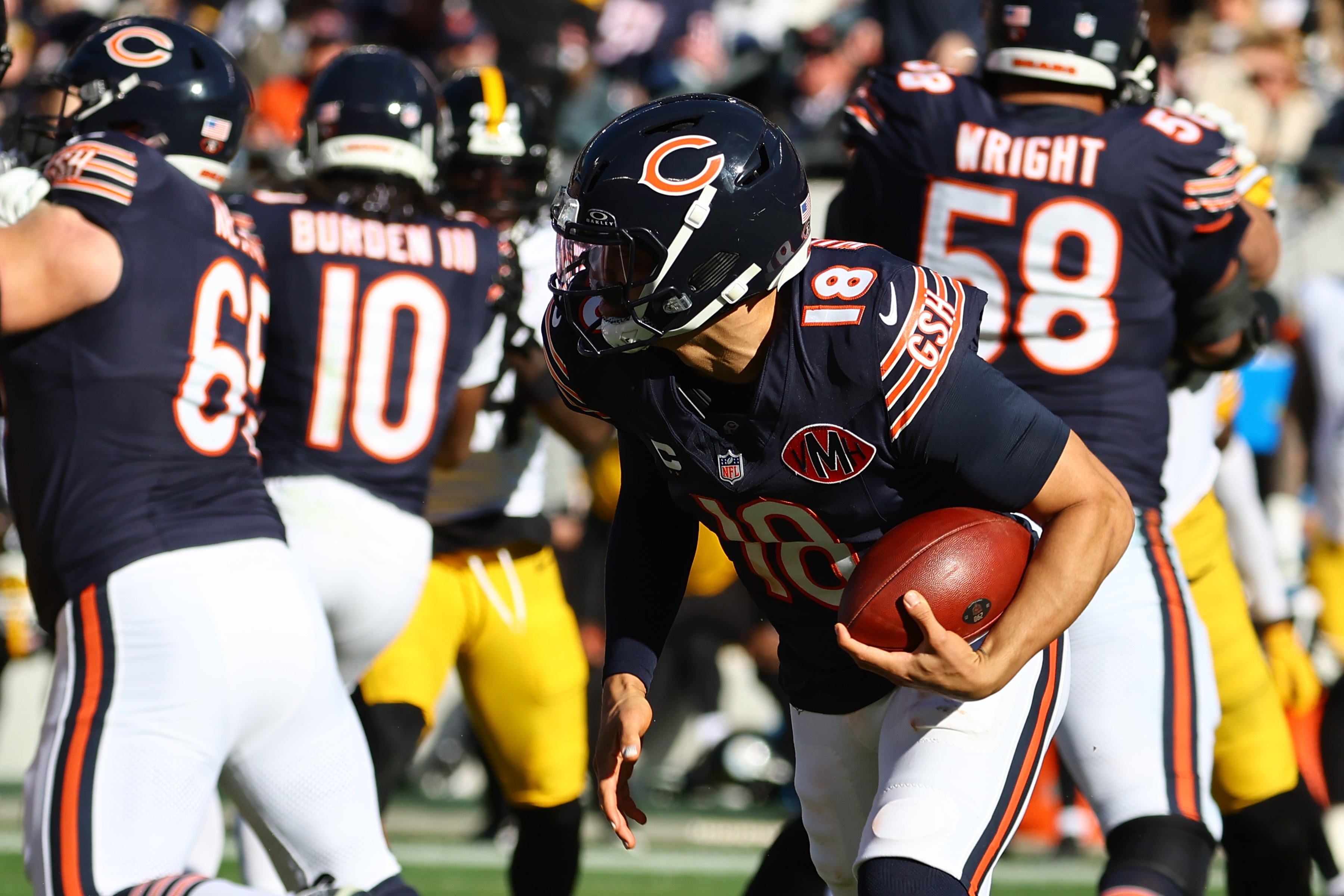 Nov 23, 2025; Chicago, Illinois, USA; Chicago Bears quarterback Caleb Williams (18) rushes the ball for a first down on fourth down during the second half at Soldier Field.