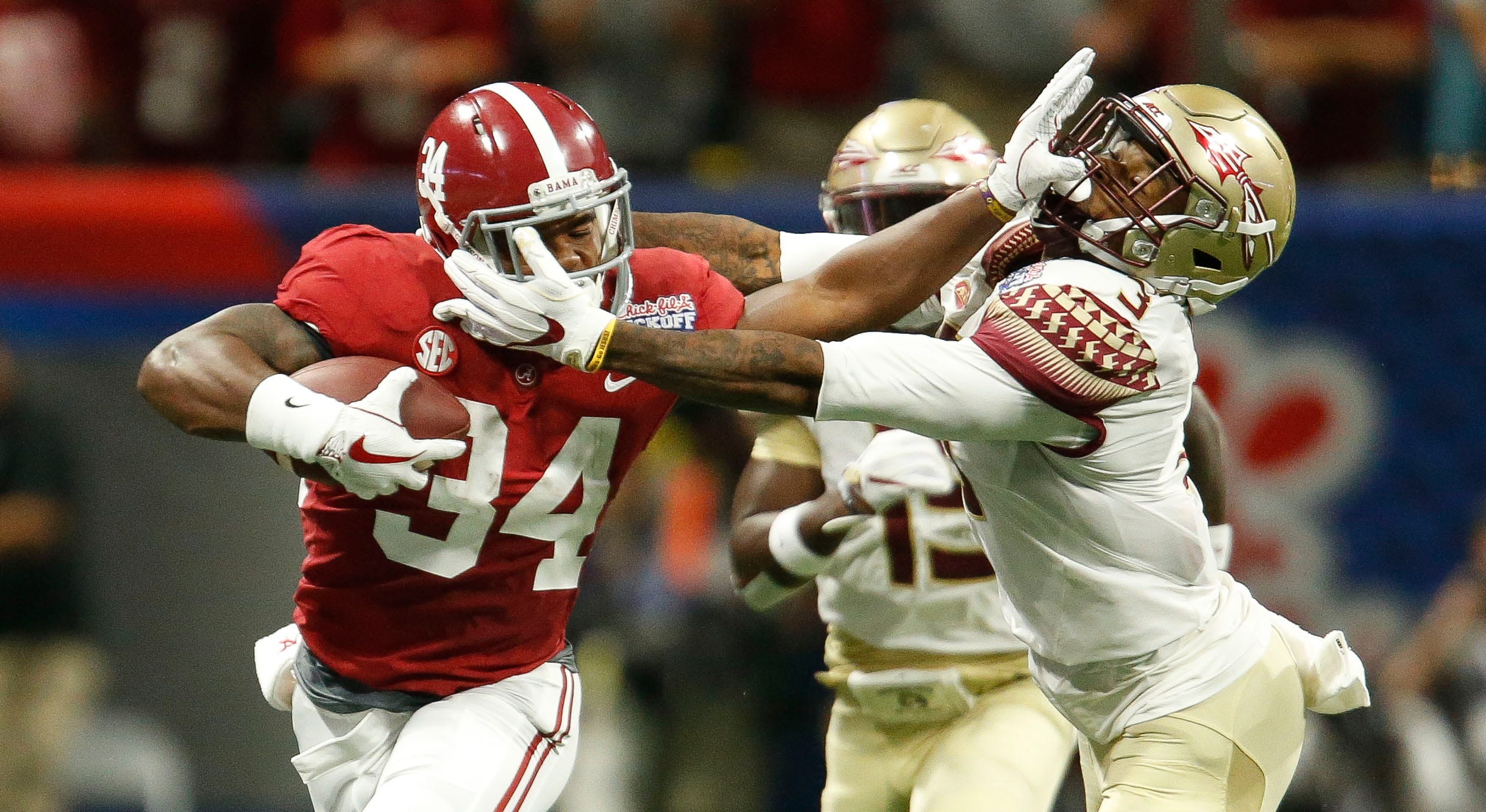 Alabama running back Damien Harris (34) stiff arms Florida State defensive back Derwin James (3) as he makes a long run in Mercedes-Benz Stadium in Atlanta Saturday, September 2, 2017. [Staff Photo/Gary Cosby Jr.]