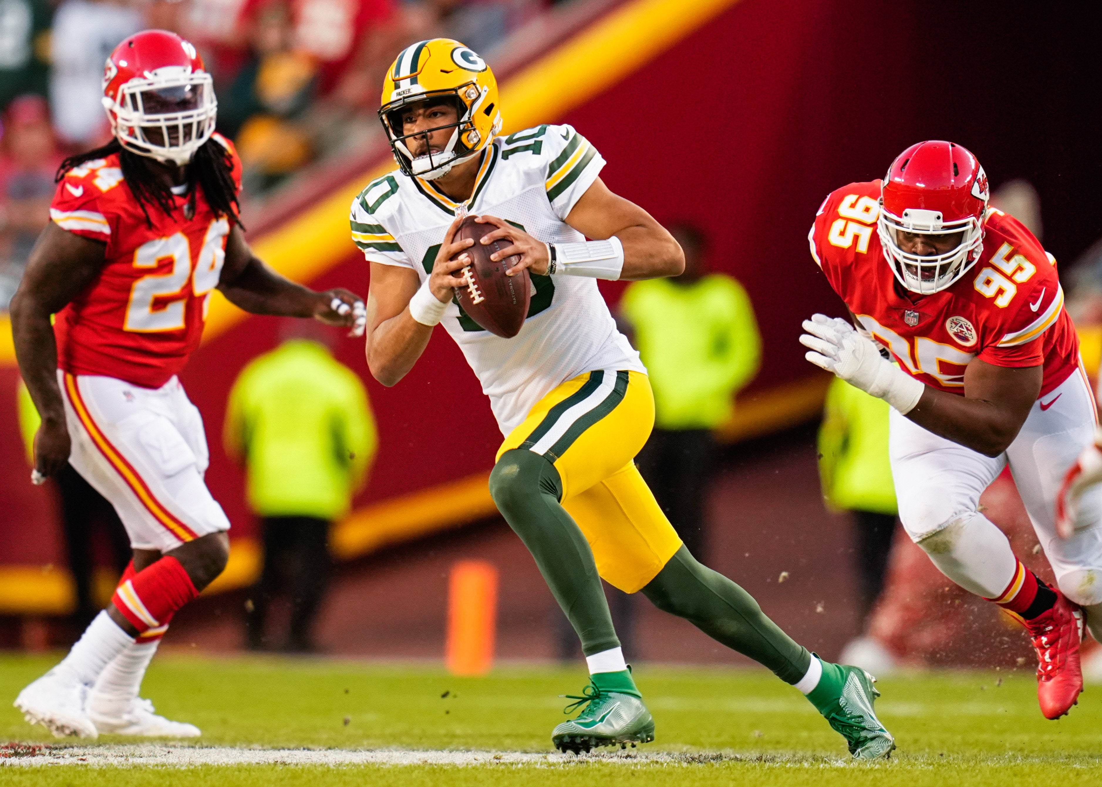 Nov 7, 2021; Kansas City, Missouri, USA; Green Bay Packers quarterback Jordan Love (10) runs past Kansas City Chiefs defensive end Melvin Ingram III (24) and defensive end Chris Jones (95) during the first half at GEHA Field at Arrowhead Stadium.