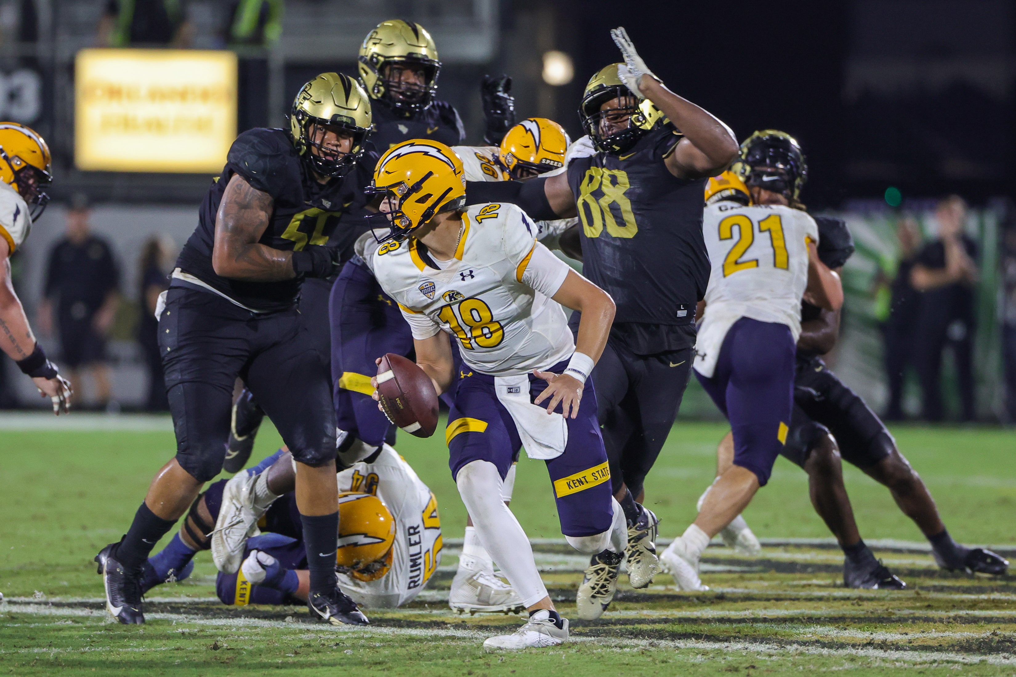 Aug 31, 2023; Orlando, Florida, USA; Kent State Golden Flashes quarterback Michael Alaimo (18) moves out to pass as UCF Knights defensive end Josh Celiscar (88) and defensive tackle John Walker (55) move in during the second half at FBC Mortgage Stadium. Mandatory Credit: Mike Watters-USA TODAY Sports battle for the ball