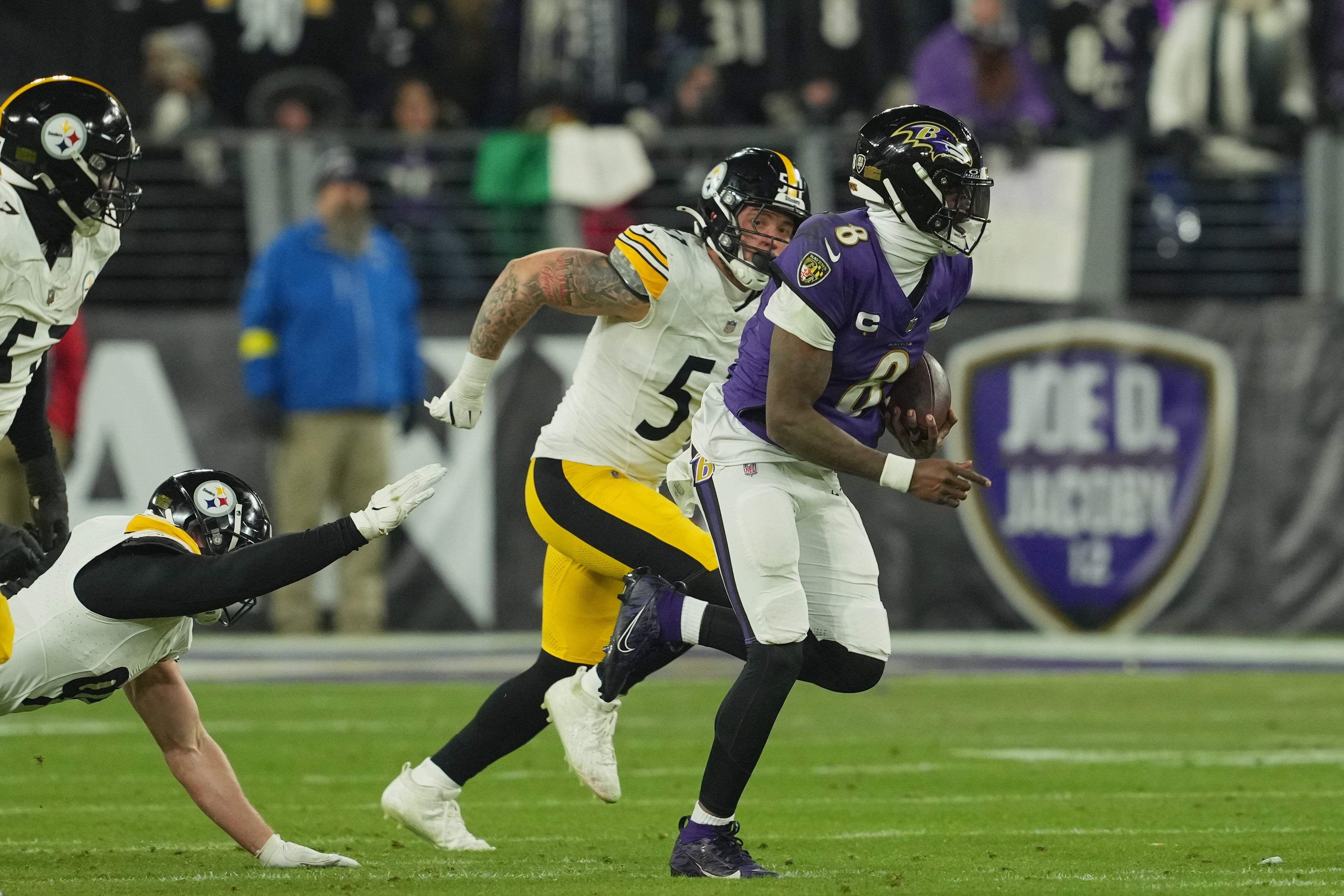 Jan 11, 2025; Baltimore, Maryland, USA; Baltimore Ravens quarterback Lamar Jackson (8) runs against Pittsburgh Steelers linebacker Nick Herbig (51) in the second quarter in an AFC wild card game at M&T Bank Stadium.