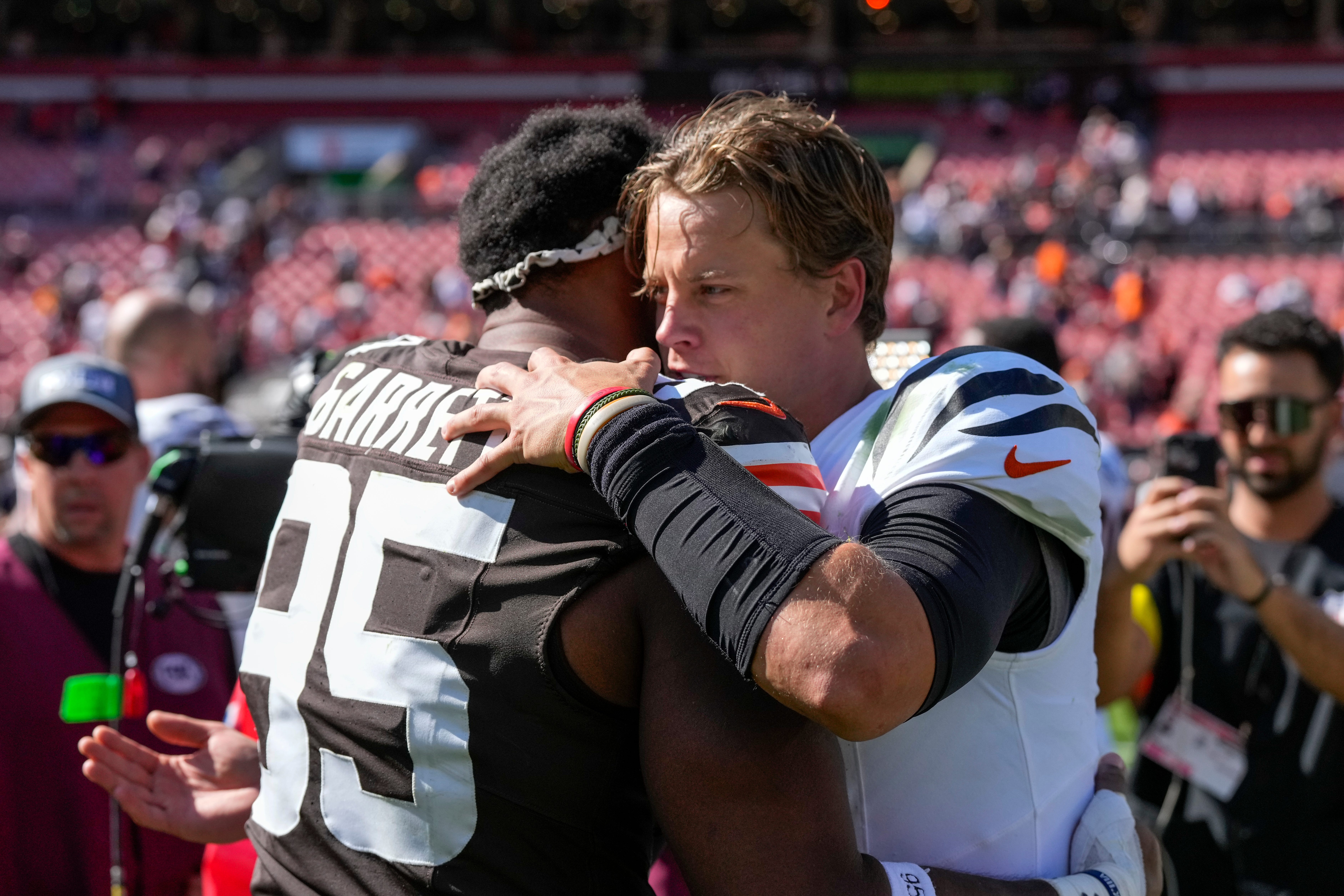 Cleveland Browns defensive end Myles Garrett (95) and Cincinnati Bengals quarterback Joe Burrow (9) hug after the fourth quarter of the NFL Week 1 game between the Cleveland Browns and the Cincinnati Bengals at Huntington Bank Field in Cleveland on Sunday, Sept. 7, 2025. The Bengals begin the season with a 17-16 win over the Browns.