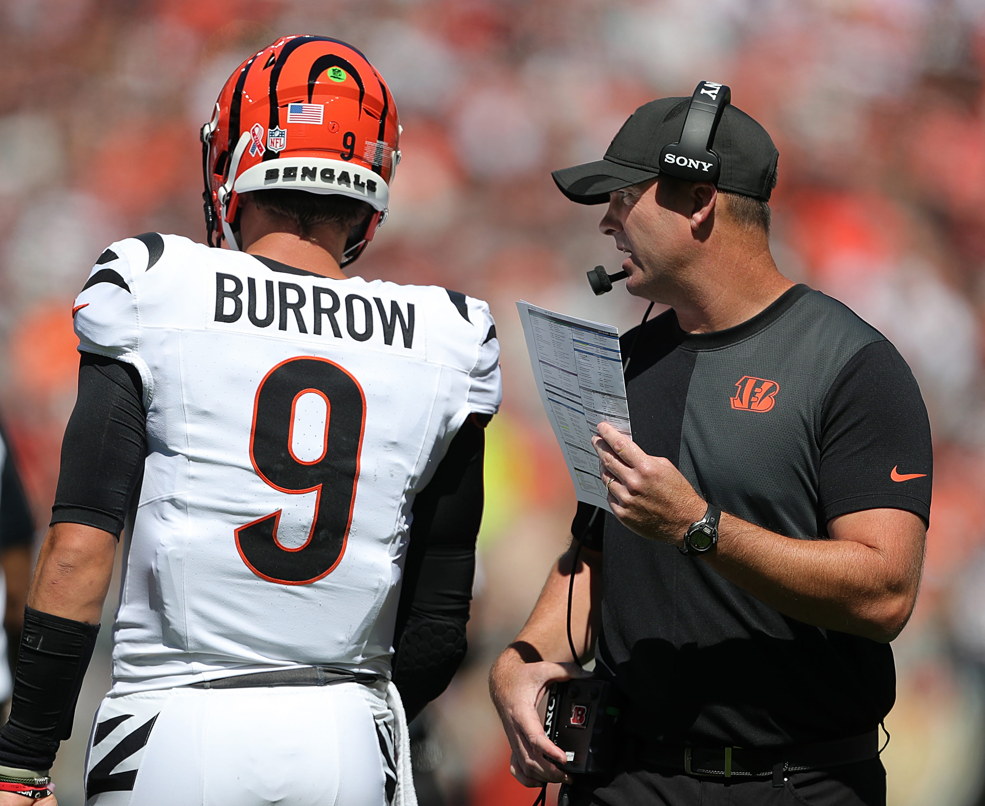 Cincinnati Bengals head coach Zac Taylor, right, has a word with quarterback Joe Burrow (9) during the first half of an NFL football game at Huntington Bank Field, Sept. 7, 2025, in Cleveland, Ohio.