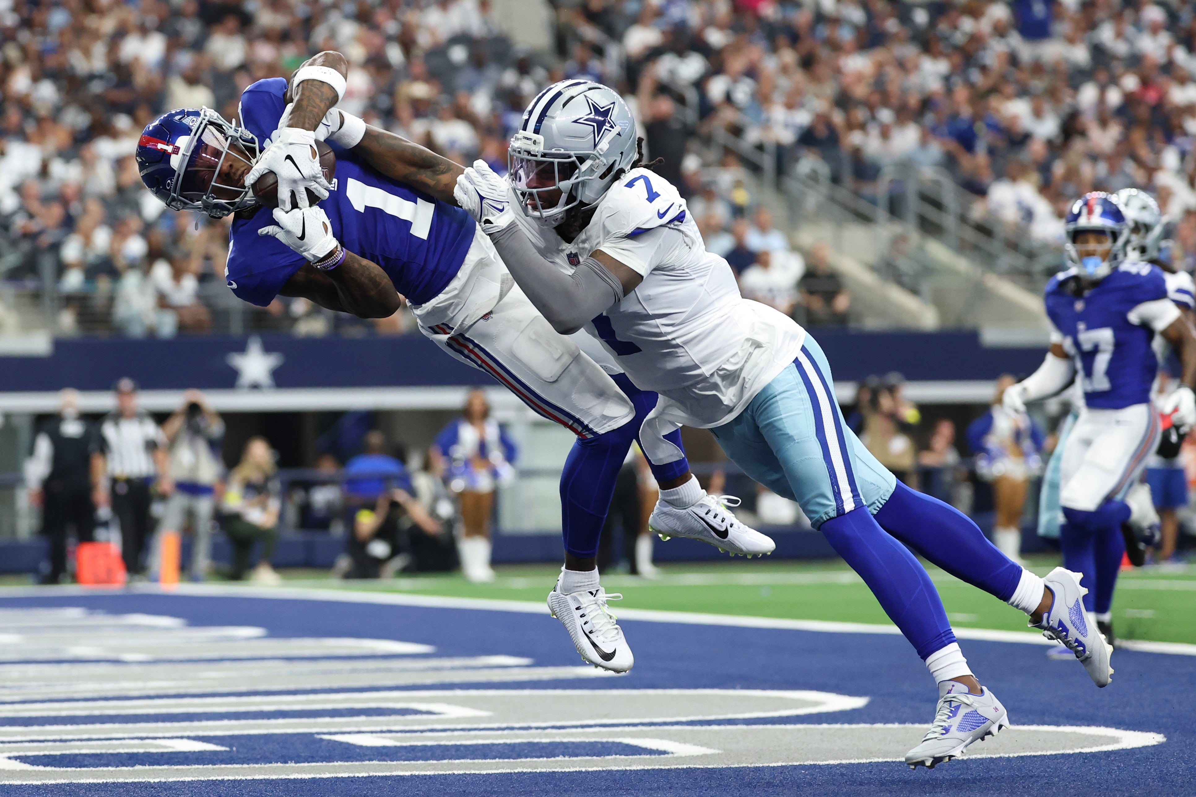 New York Giants wide receiver Malik Nabers (1) makes a catch for a touchdown against Dallas Cowboys cornerback Trevon Diggs (7) during the second quarter at AT&T Stadium.