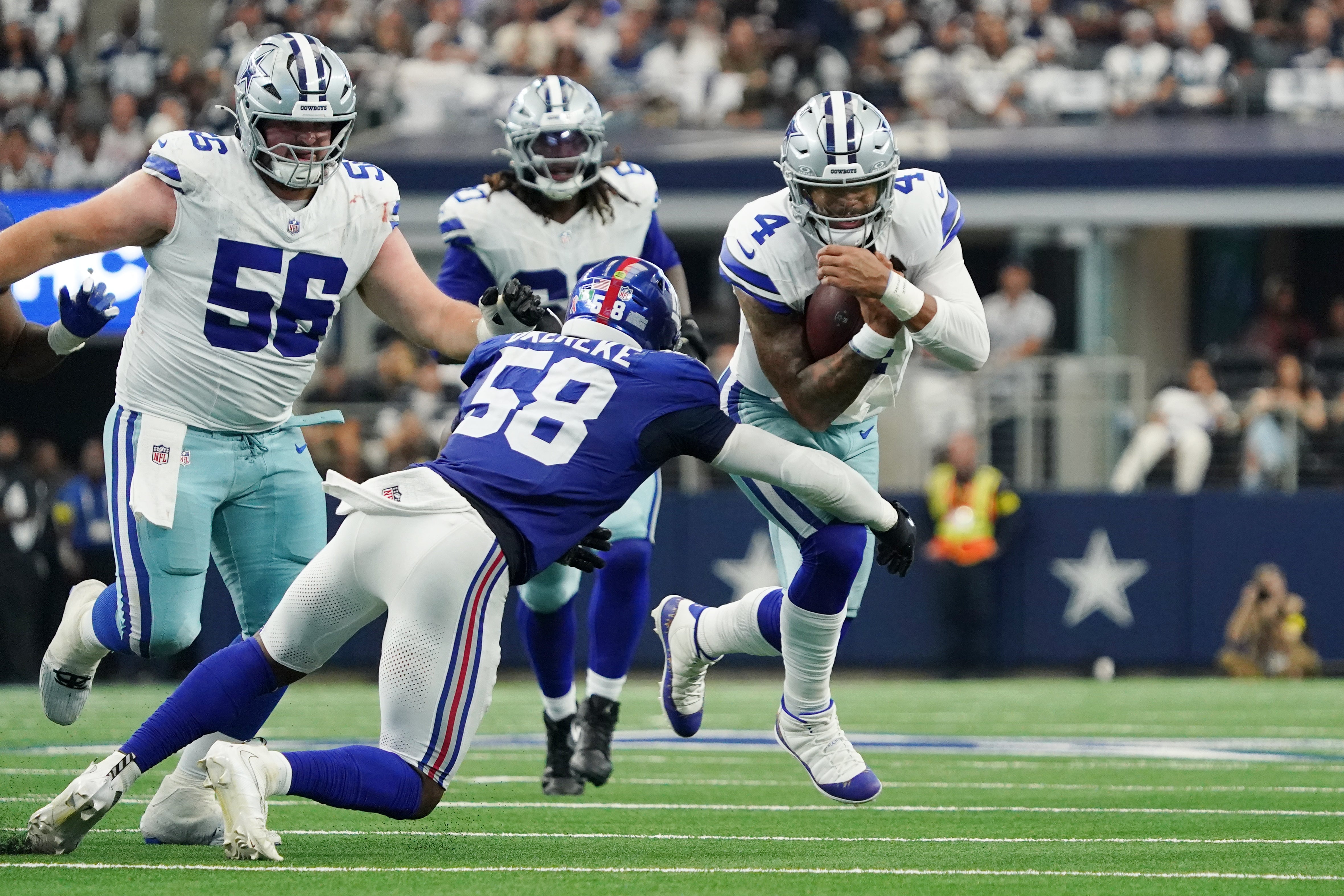 Arlington, Texas, USA; Dallas Cowboys quarterback Dak Prescott (4) runs with the ball against New York Giants linebacker Bobby Okereke (58) during the third quarter at AT&T Stadium.
