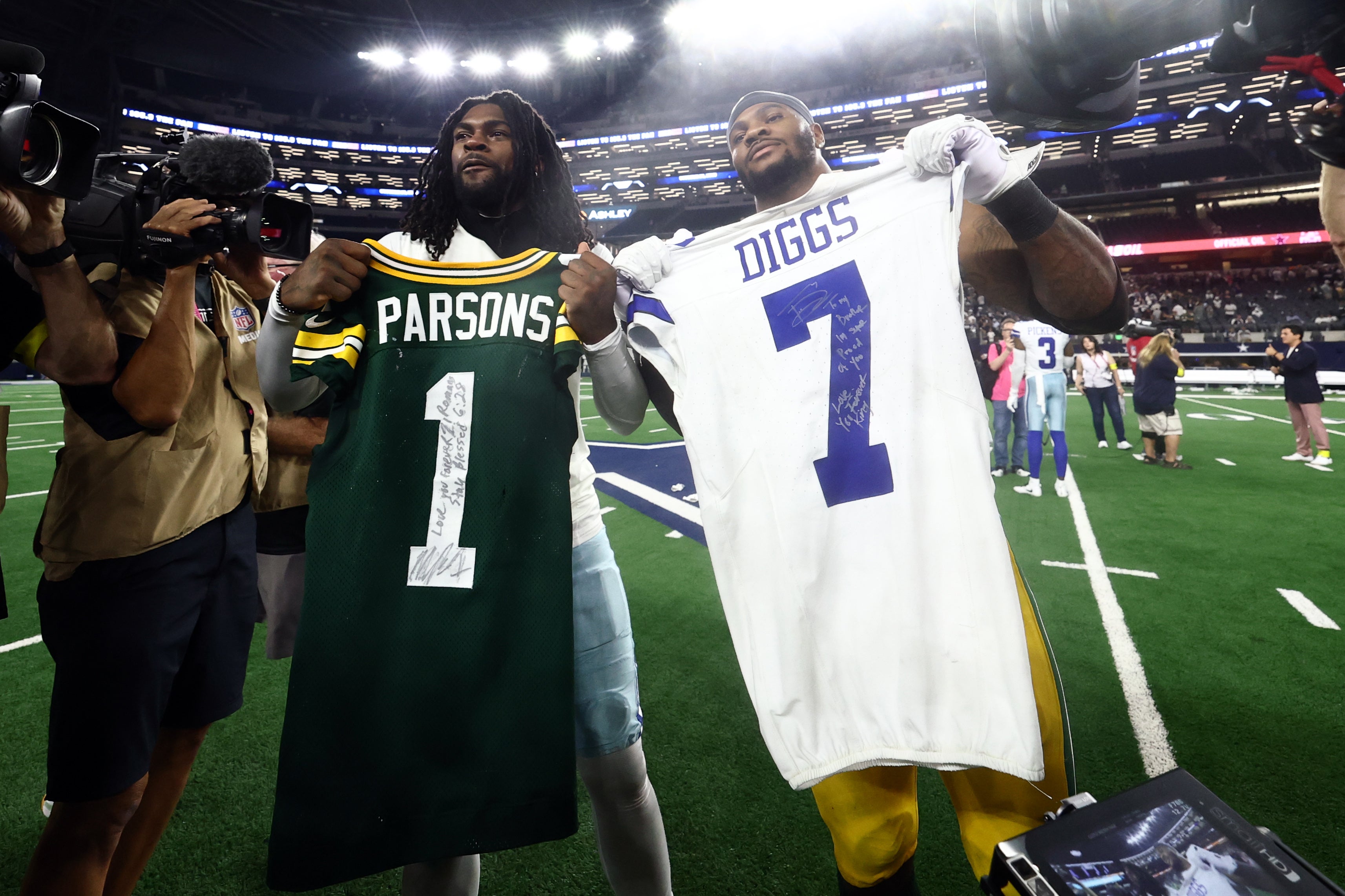 Sep 28, 2025; Arlington, Texas, USA; Green Bay Packers defensive end Micah Parsons (1) and Dallas Cowboys cornerback Trevon Diggs (7) exchange jerseys after the game at AT&T Stadium.