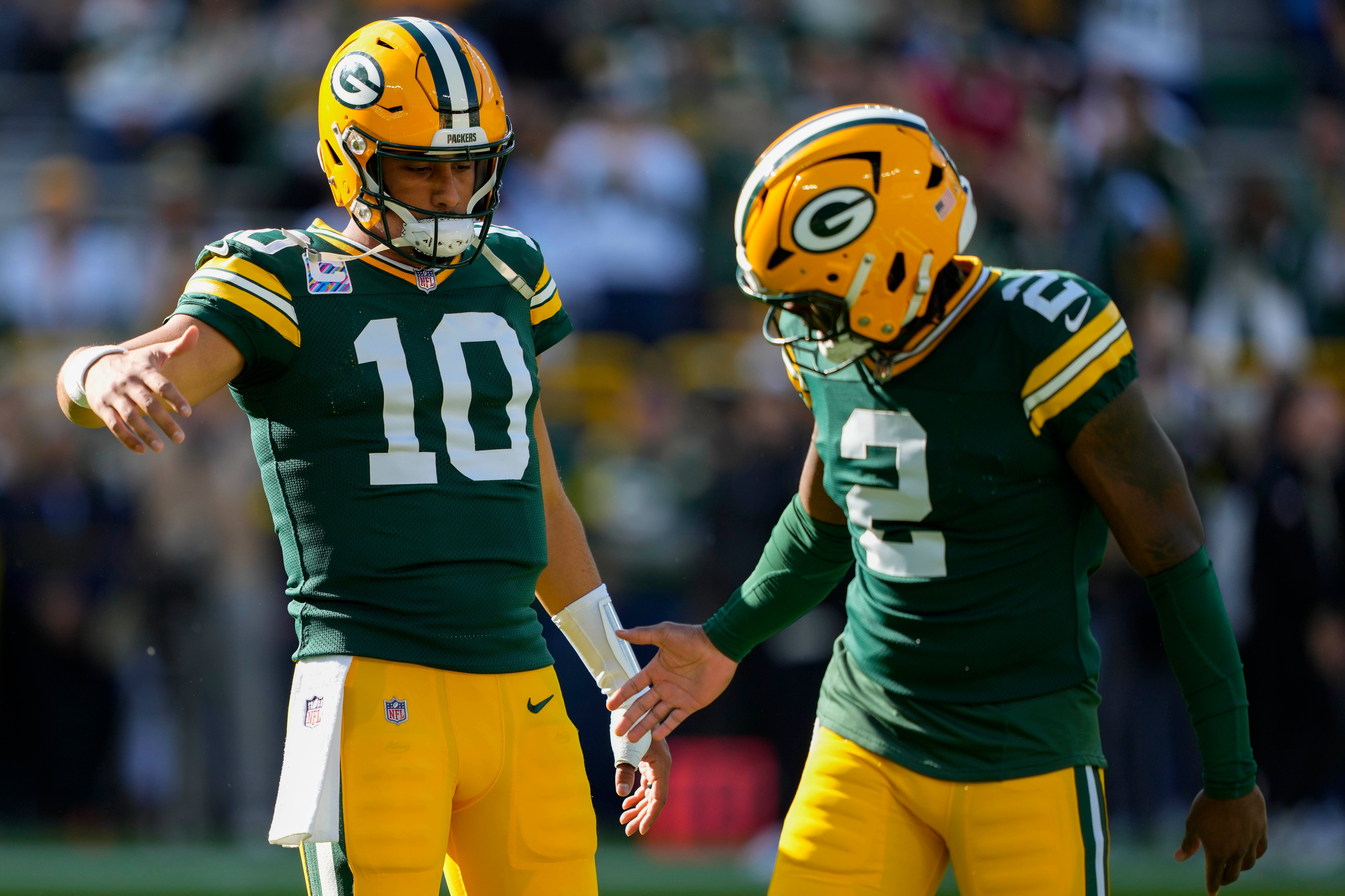Oct 12, 2025; Green Bay, Wisconsin, USA; Green Bay Packers quarterback Jordan Love (10) greets quarterback Malik Willis (2) during warmups prior to the game against the Cincinnati Bengals at Lambeau Field.