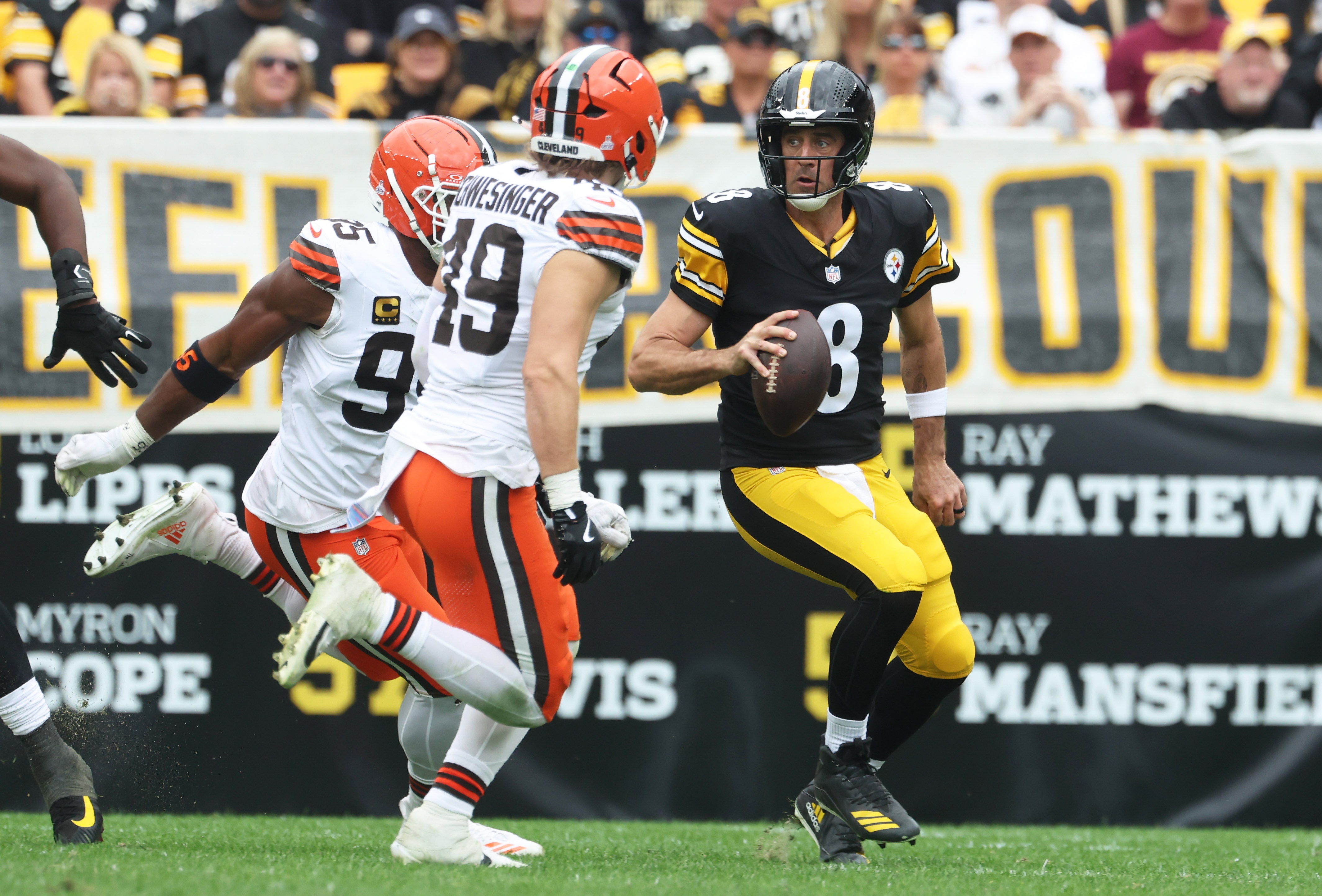 Oct 12, 2025; Pittsburgh, Pennsylvania, USA; Cleveland Browns defensive end Myles Garrett (95) and linebacker Carson Schwesinger (49) chase Pittsburgh Steelers quarterback Aaron Rodgers (8) during the second quarter at Acrisure Stadium.