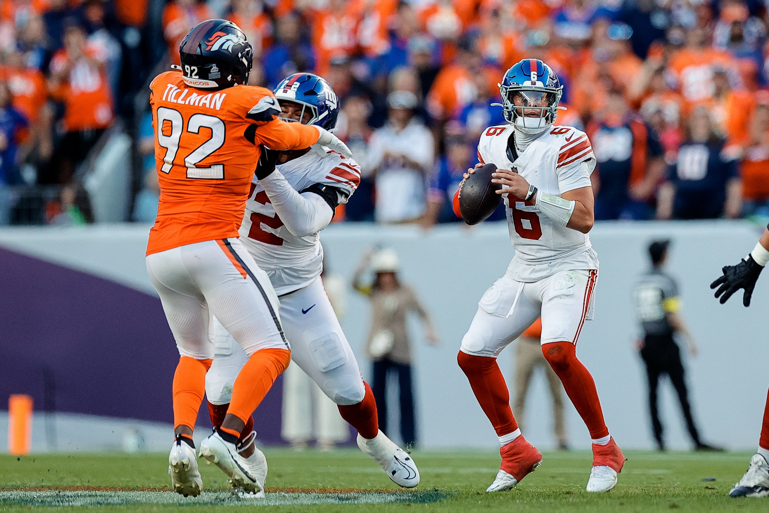 Oct 19, 2025; Denver, Colorado, USA; New York Giants quarterback Jaxson Dart (6) drops back to pass as guard Jermaine Eluemunor (72) defends against Denver Broncos linebacker Dondrea Tillman (92) in the fourth quarter at Empower Field at Mile High.