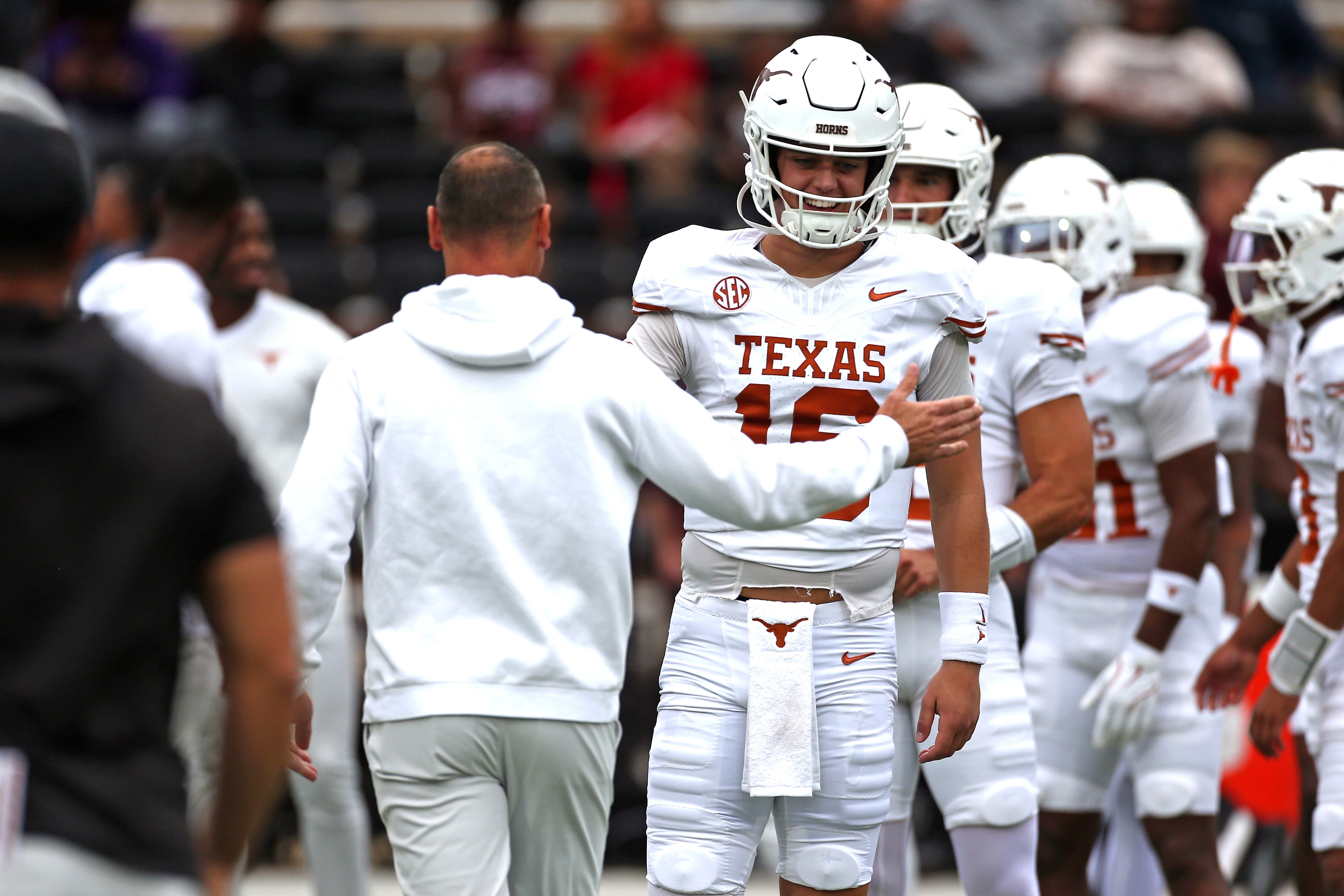 Oct 25, 2025; Starkville, Mississippi, USA; Texas Longhorns quarterback Arch Manning (16) runs the ball with head coach Steve Sarkisian during warm ups prior to the game against the Mississippi State Bulldogs at Davis Wade Stadium at Scott Field. Mandatory Credit: Petre Thomas-Imagn Images
