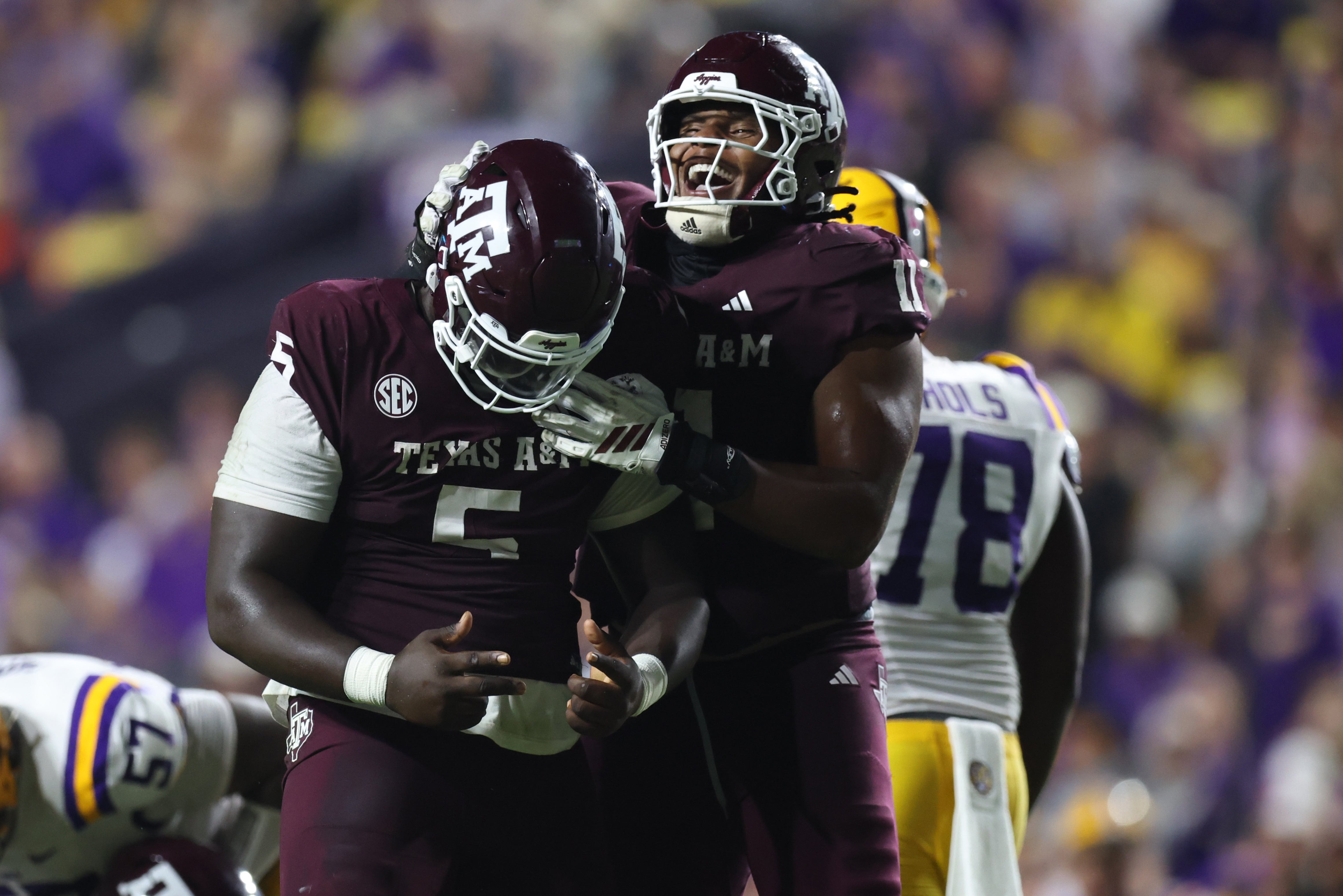 Oct 25, 2025; Baton Rouge, Louisiana, USA; Texas A&M Aggies defensive tackle DJ Hicks (5) celebrates with defensive tackle Tyler Onyedim (11) after a play during the second half against the Louisiana State Tigers at Tiger Stadium.