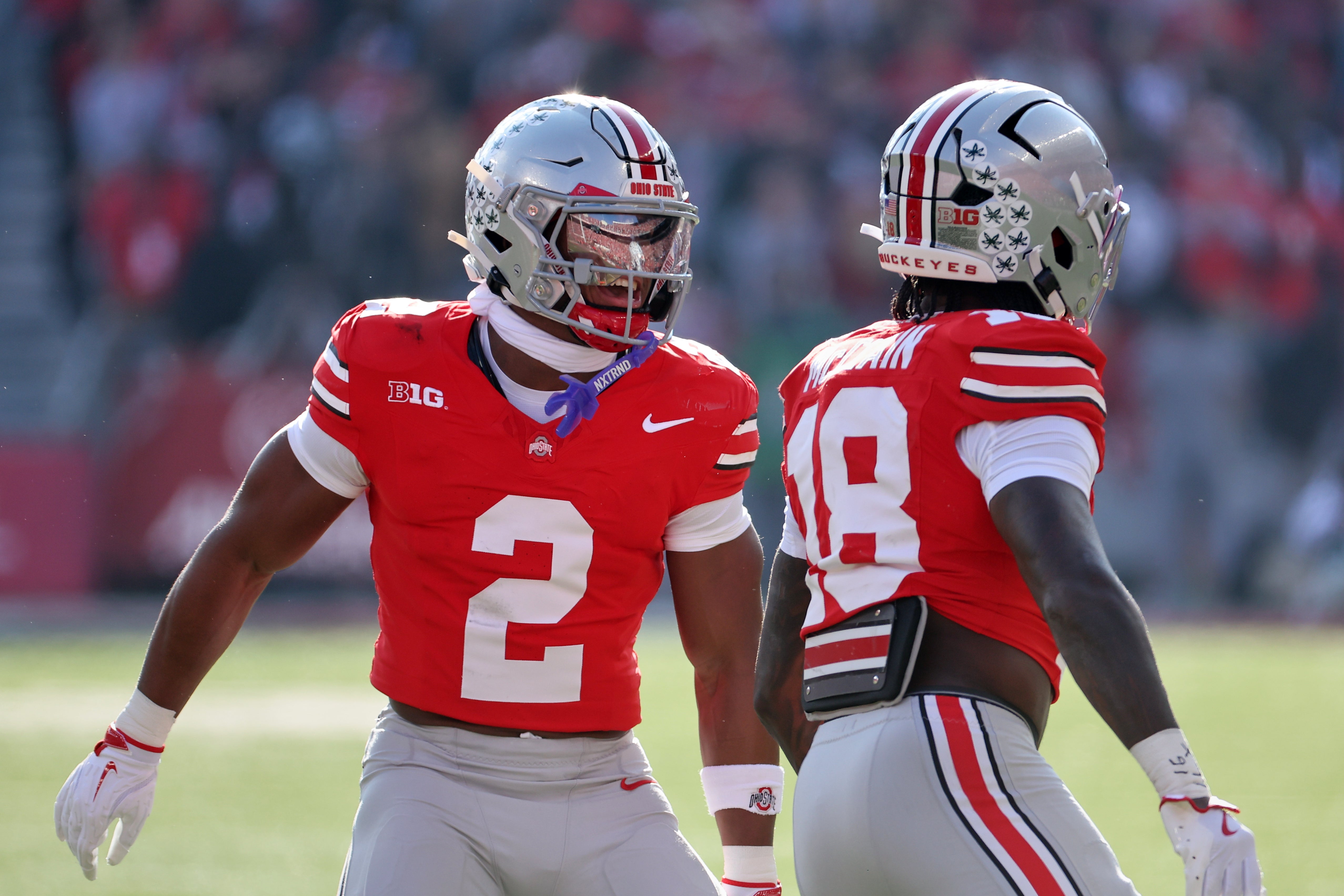 Nov 22, 2025; Columbus, Ohio, USA; Ohio State Buckeyes safeties Caleb Downs (2) and Jaylen McClain (18) celebrate a defensive stop on fourth down against the Rutgers Scarlet Knights during the first quarter at Ohio Stadium.