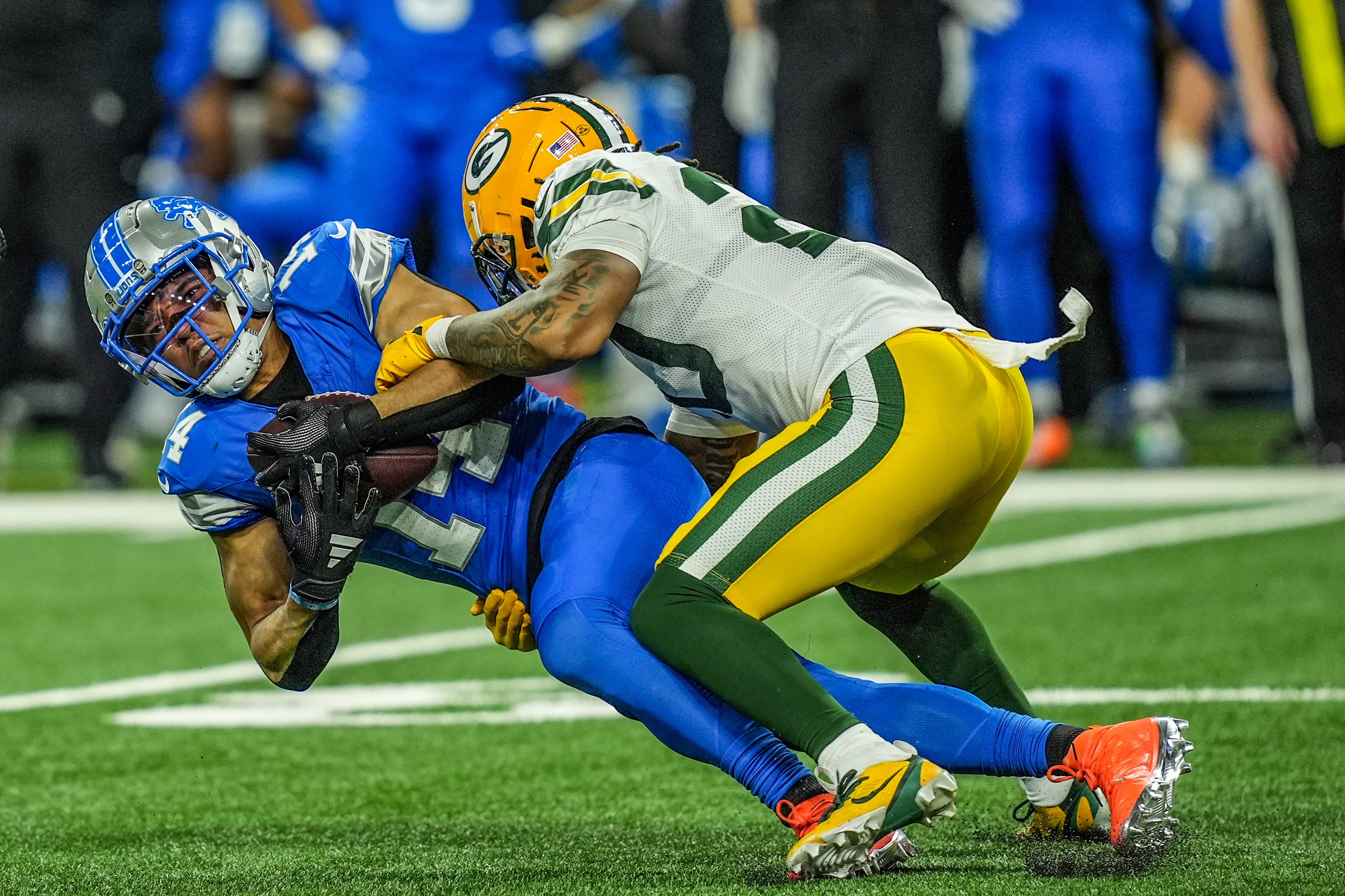 Detroit Lions wide receiver Amon-Ra St. Brown makes a catch while hit by Green Bay Packers safety Javon Bullard during the Thursday Night Football game at Ford Field in Detroit on Thursday, Dec. 5, 2024.