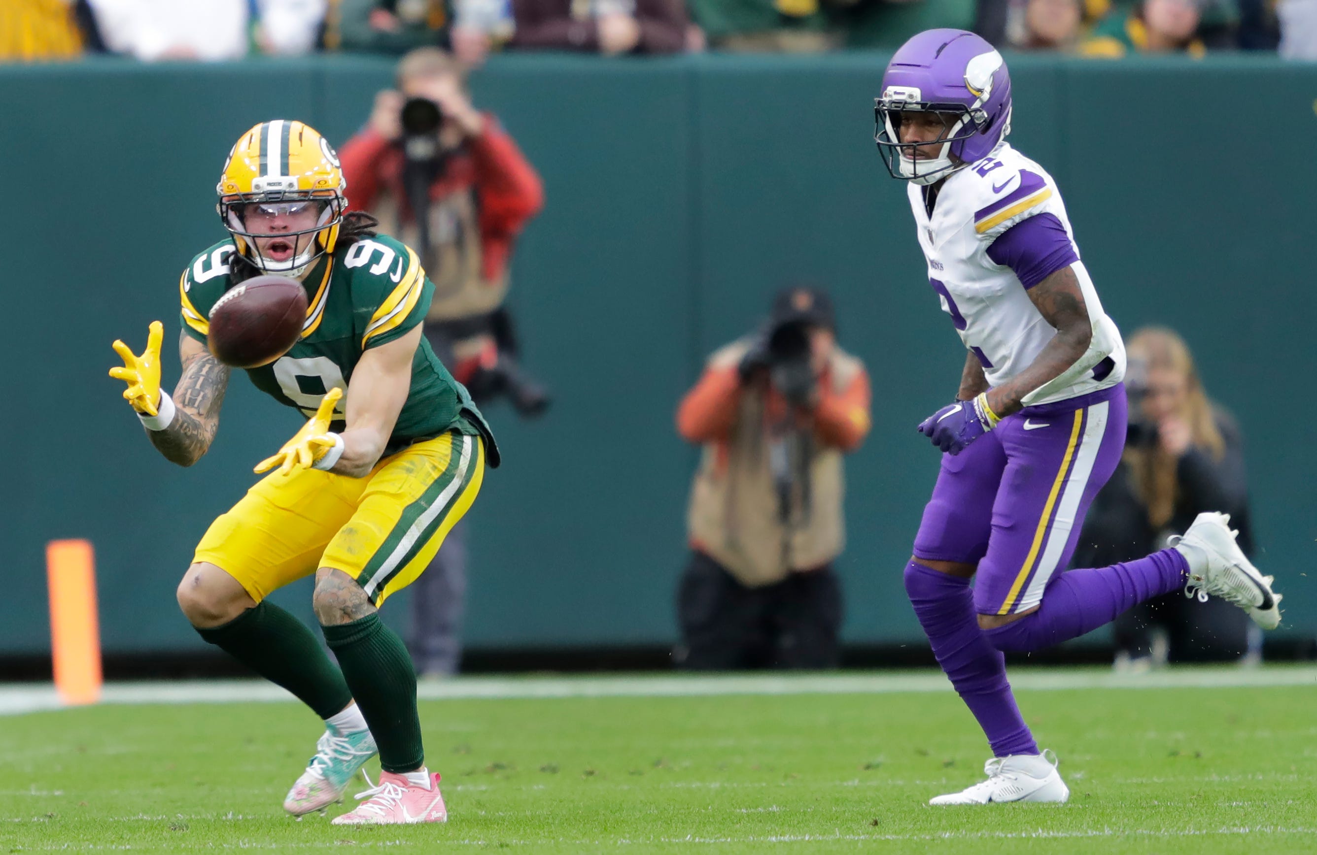 Green Bay Packers wide receiver Christian Watson (9) makes a first down catch against Minnesota Vikings cornerback Isaiah Rodgers (2) in the fourth quarter during their football game Sunday, November 23, 2025, at Lambeau Field in Green Bay, Wisconsin.