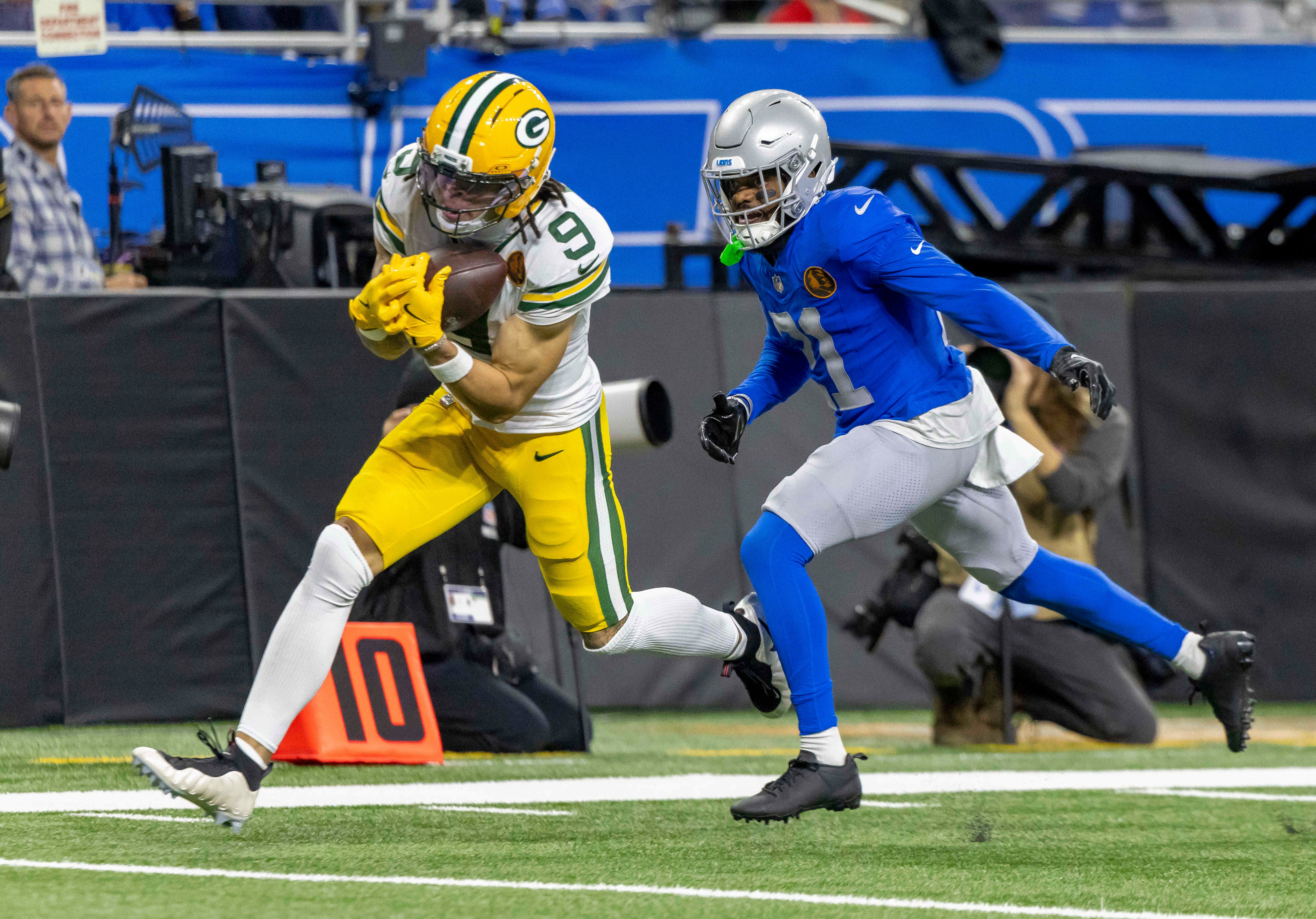 Nov 27, 2025; Detroit, Michigan, USA; Green Bay Packers wide receiver Christian Watson (9) catches a pass against Detroit Lions cornerback Amik Robertson (21) during the third quarter at Ford Field.