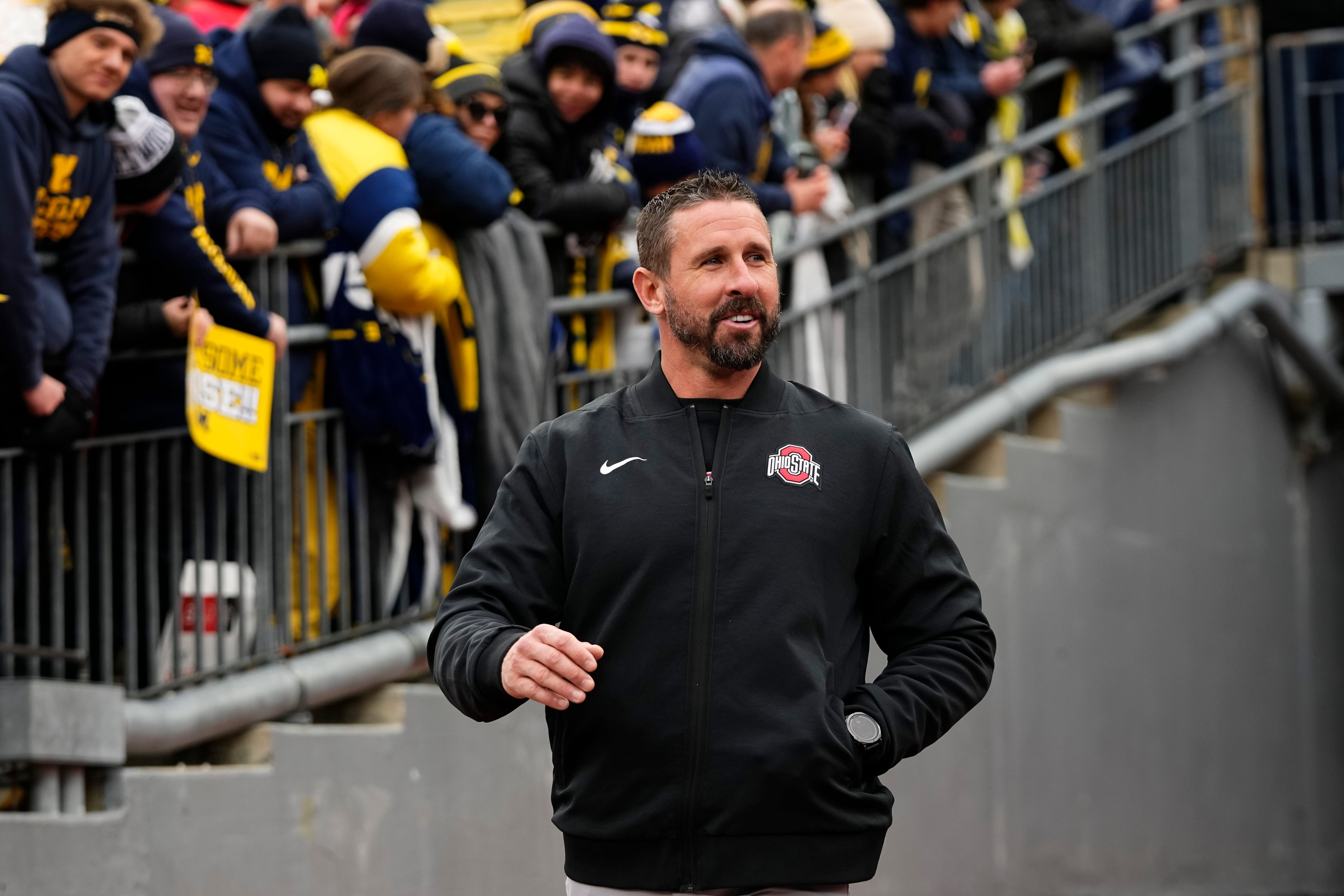 Ohio State Buckeyes offensive coordinator Brian Hartline laughs after hearing jeers as he walks onto the field prior to the NCAA football game against the Michigan Wolverines at Michigan Stadium in Ann Arbor, Mich. on Nov. 29, 2025.
