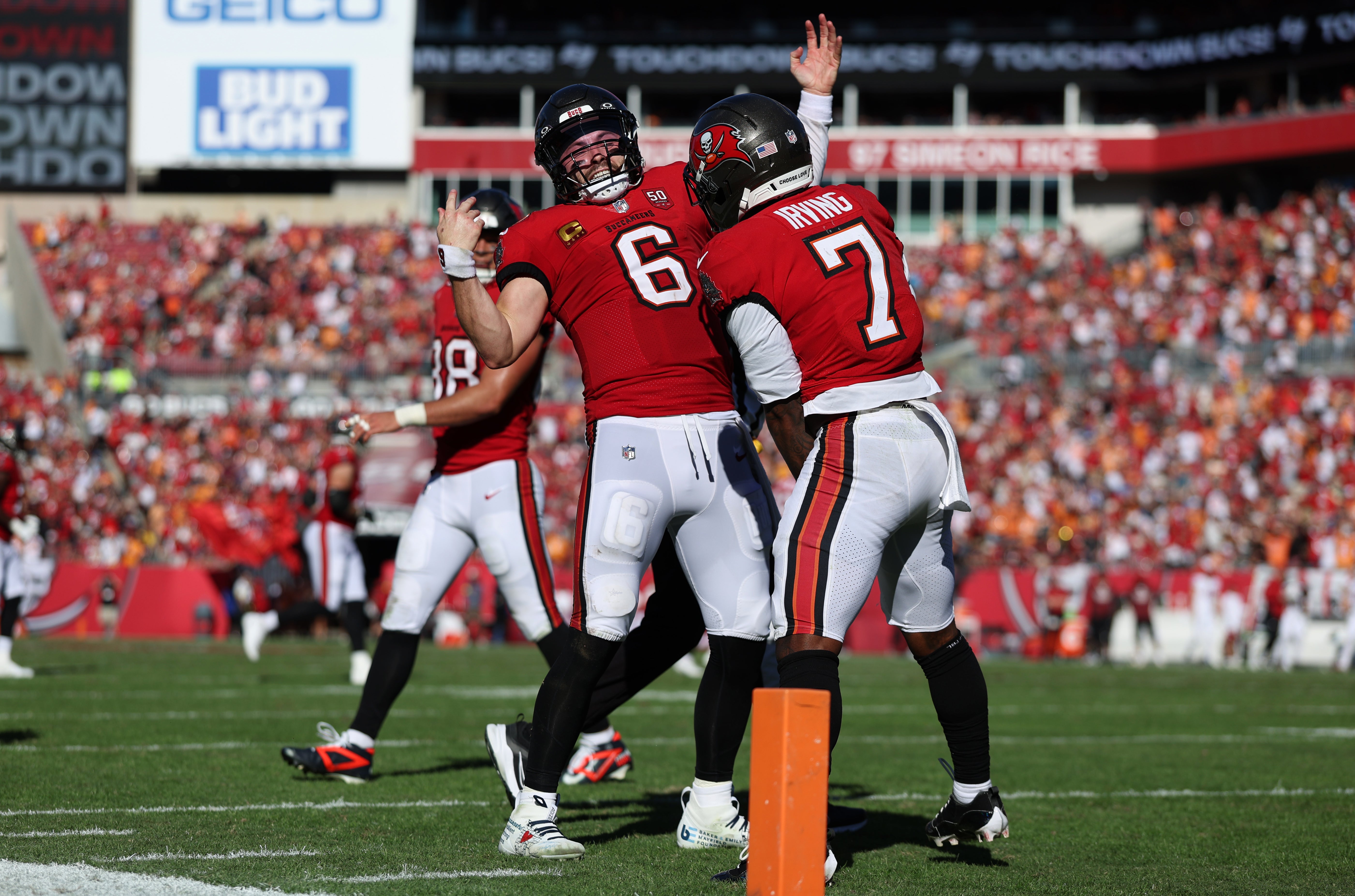 Nov 30, 2025; Tampa, Florida, USA; Tampa Bay Buccaneers running back Bucky Irving (7) celebrates with quarterback Baker Mayfield (6) after a touchdown during the second half against the Arizona Cardinals at Raymond James Stadium.