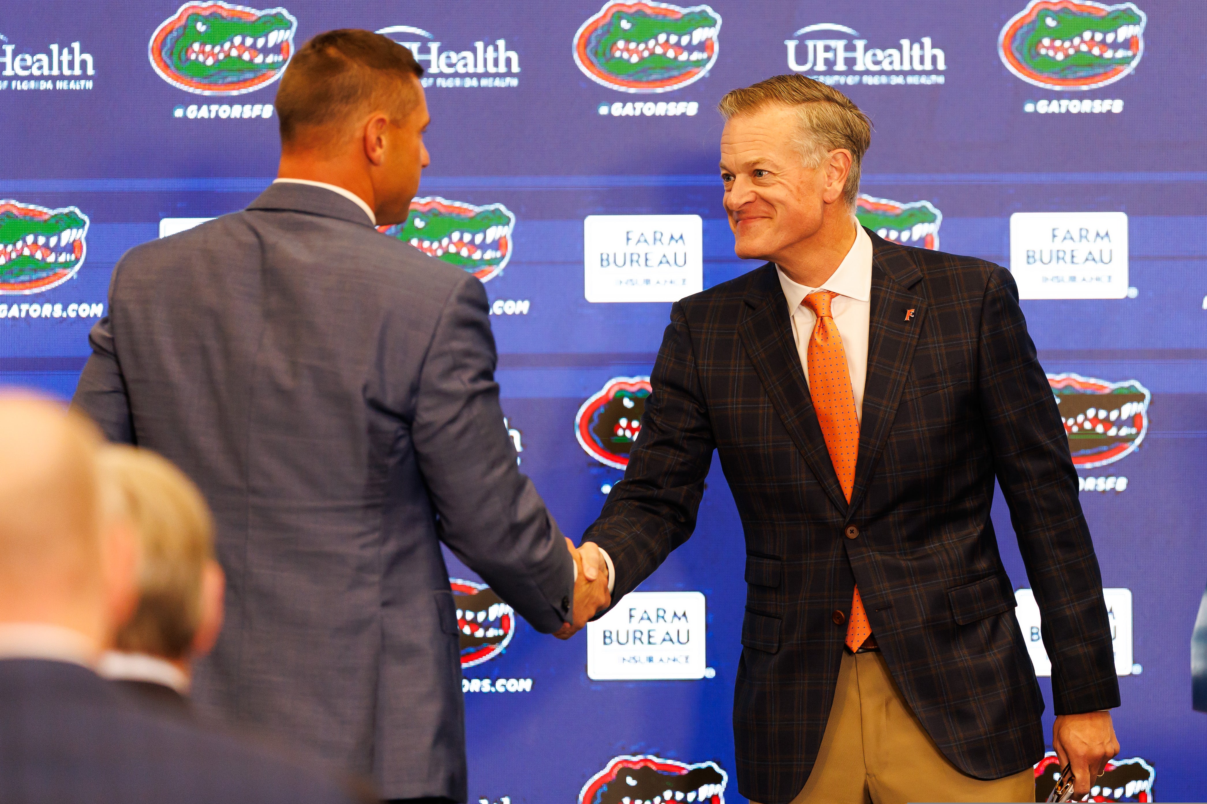 Dec 1, 2025; Gainesville, FL, USA; Florida Gators athletic director Scott Stricklin shakes hands with Florida Gators head coach Jon Sumrall during the press conference at the Heavener Football Training Center at the University of Florida.