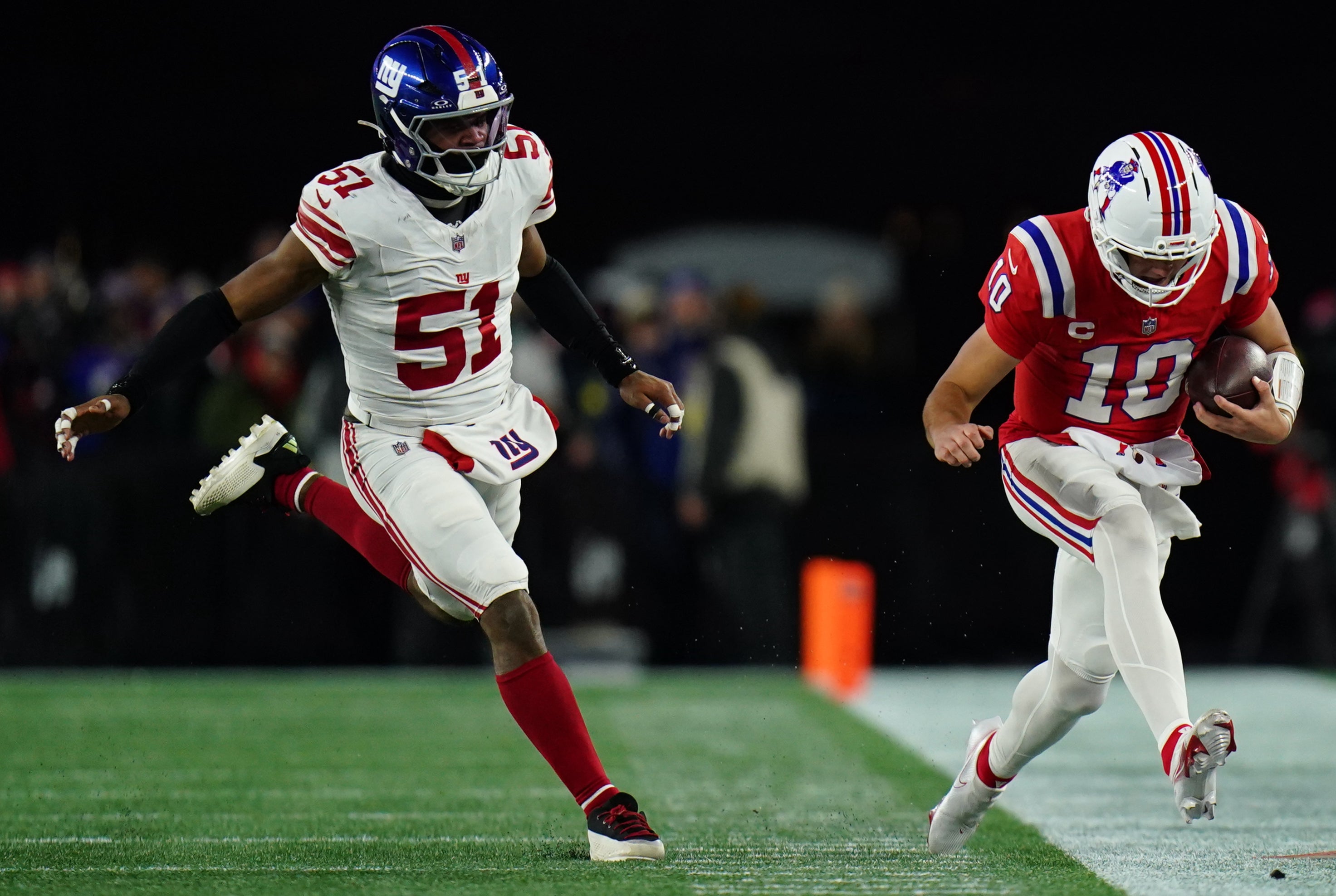 Dec 1, 2025; Foxborough, Massachusetts, USA; New England Patriots quarterback Drake Maye (10) runs the ball against New York Giants linebacker Abdul Carter (51) during the third quarter at Gillette Stadium.