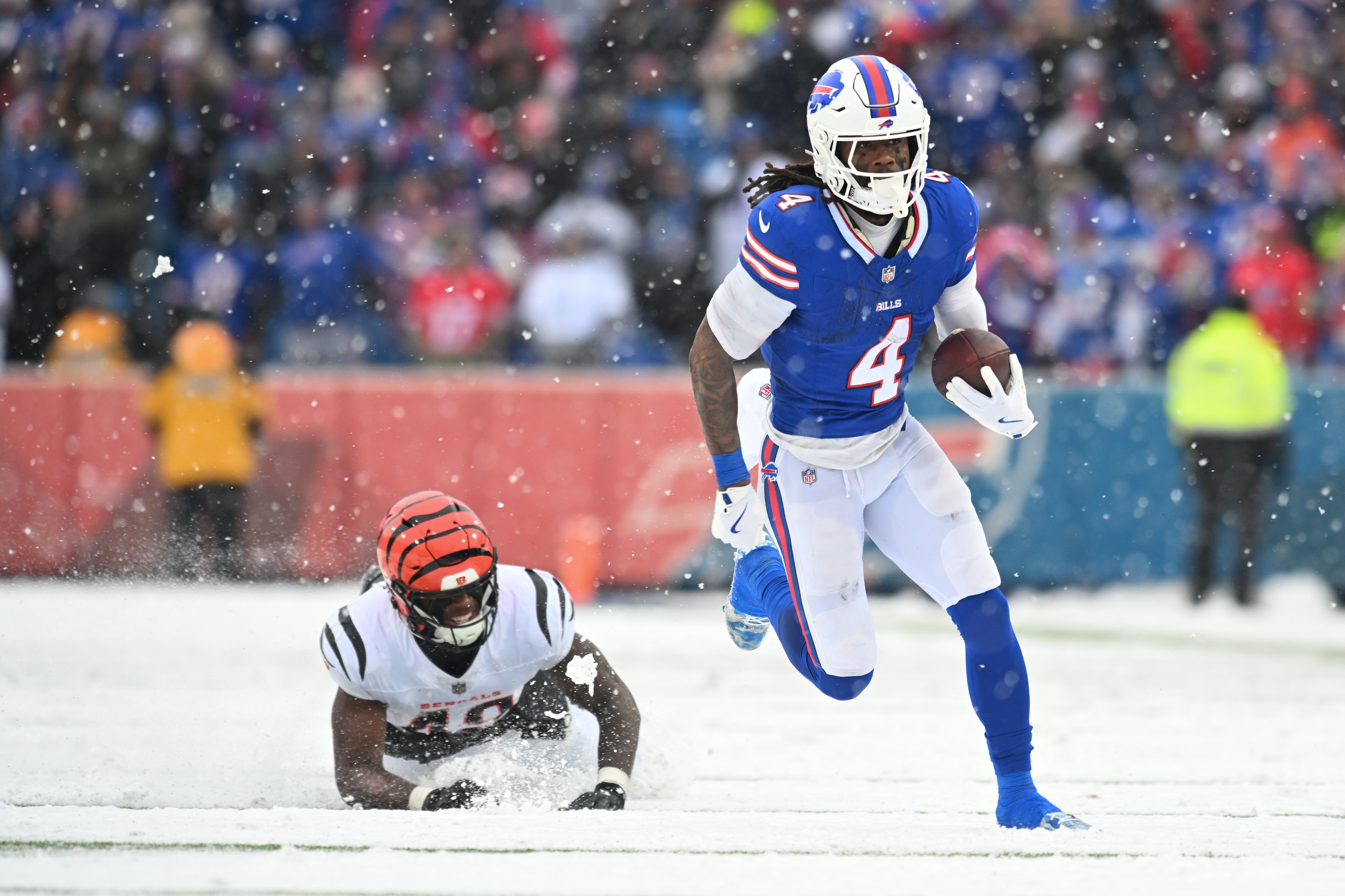 Dec 7, 2025; Orchard Park, New York, USA; Buffalo Bills running back James Cook III (4) runs with the ball while defended by Cincinnati Bengals linebacker Barrett Carter (49) in the second half at Highmark Stadium.