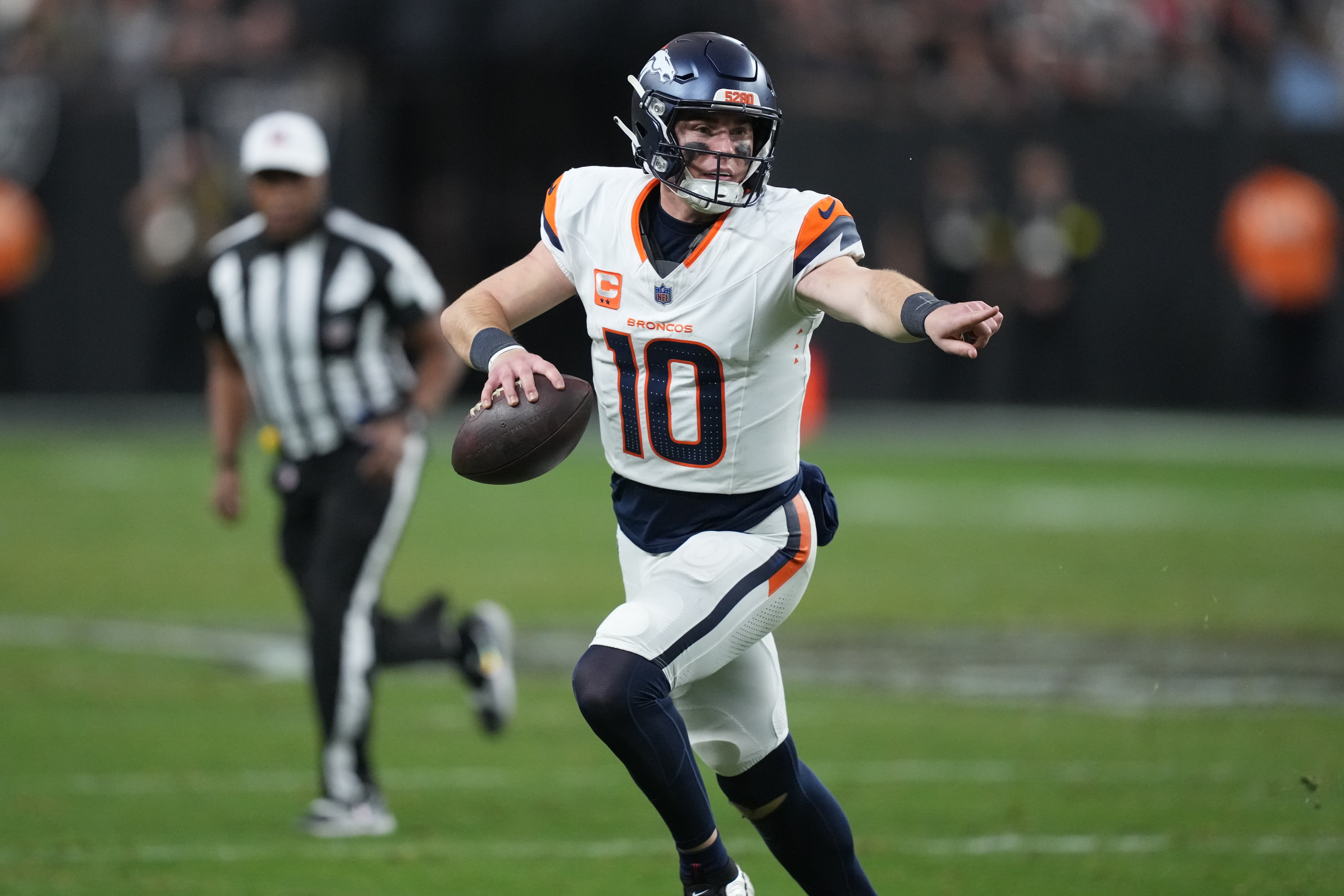 Dec 7, 2025; Paradise, Nevada, USA; Denver Broncos quarterback Bo Nix (10) scrambles against the Las Vegas Raiders during the second half at Allegiant Stadium.
