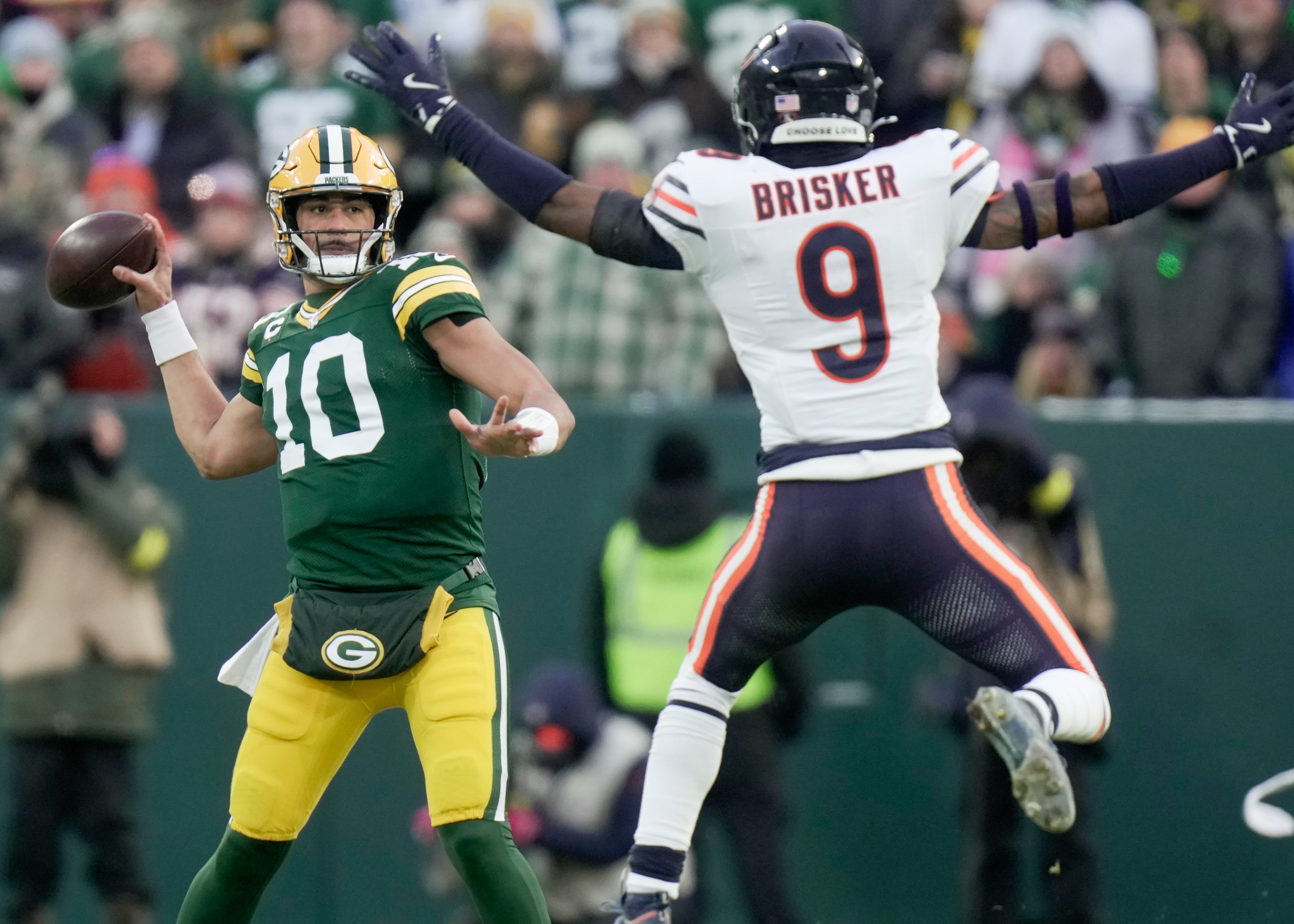 Dec 7, 2025; Green Bay, Wisconsin, USA; Green Bay Packers quarterback Jordan Love (10) throws a pass while pressured by Chicago Bears safety Jaquan Brisker (9) during the first quarter at Lambeau Field.