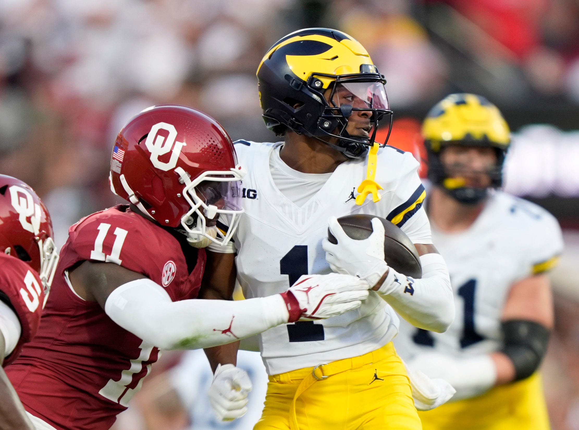 Oklahoma's Kobie McKinzie (11) tackles Michigan's Donaven McCulley (1) in the first half of the college football game between the University of Oklahoma Sooner and the University of Michigan Wolverines at the Gaylord Family-Oklahoma Memorial Stadium in Norman, Okla., Saturday, Sept. 6, 2025.