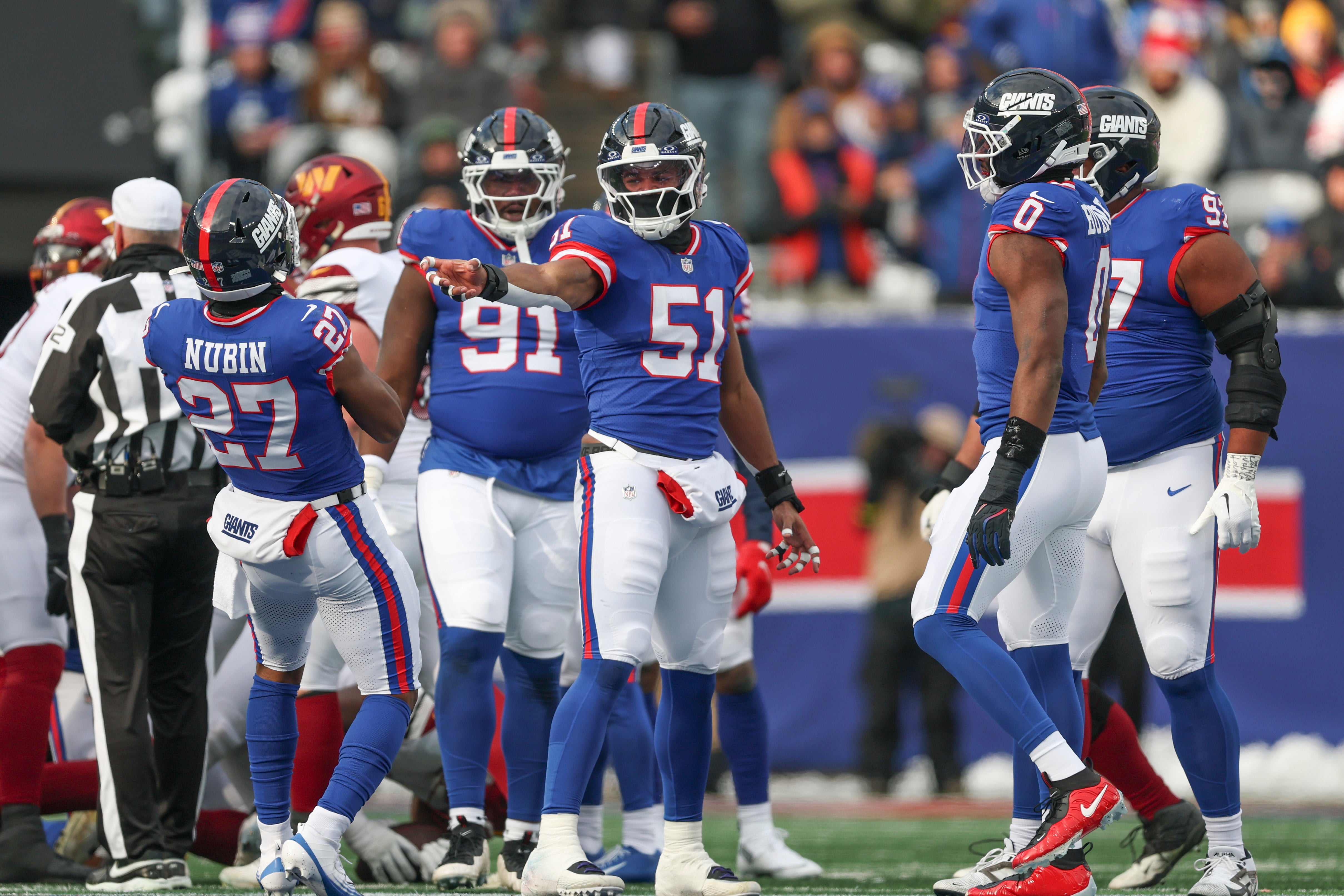 Dec 14, 2025; East Rutherford, New Jersey, USA; New York Giants linebacker Abdul Carter (51) and safety Tyler Nubin (27) celebrate a defensive stop during the first quarter against the Washington Commanders at MetLife Stadium.