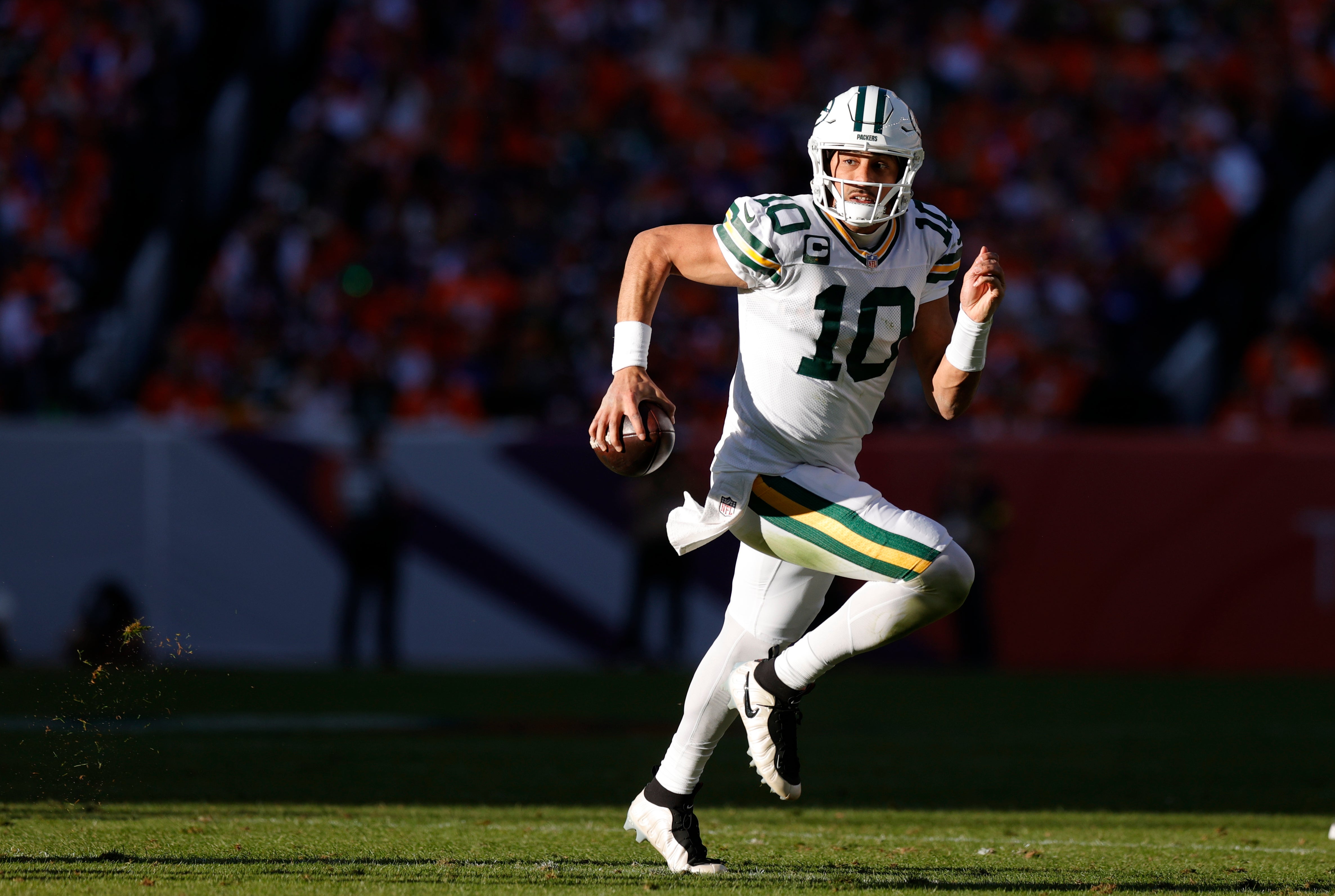 Dec 14, 2025; Denver, Colorado, USA; Green Bay Packers quarterback Jordan Love (10) runs for a gain during the first quarter against the Denver Broncos at Empower Field at Mile High.