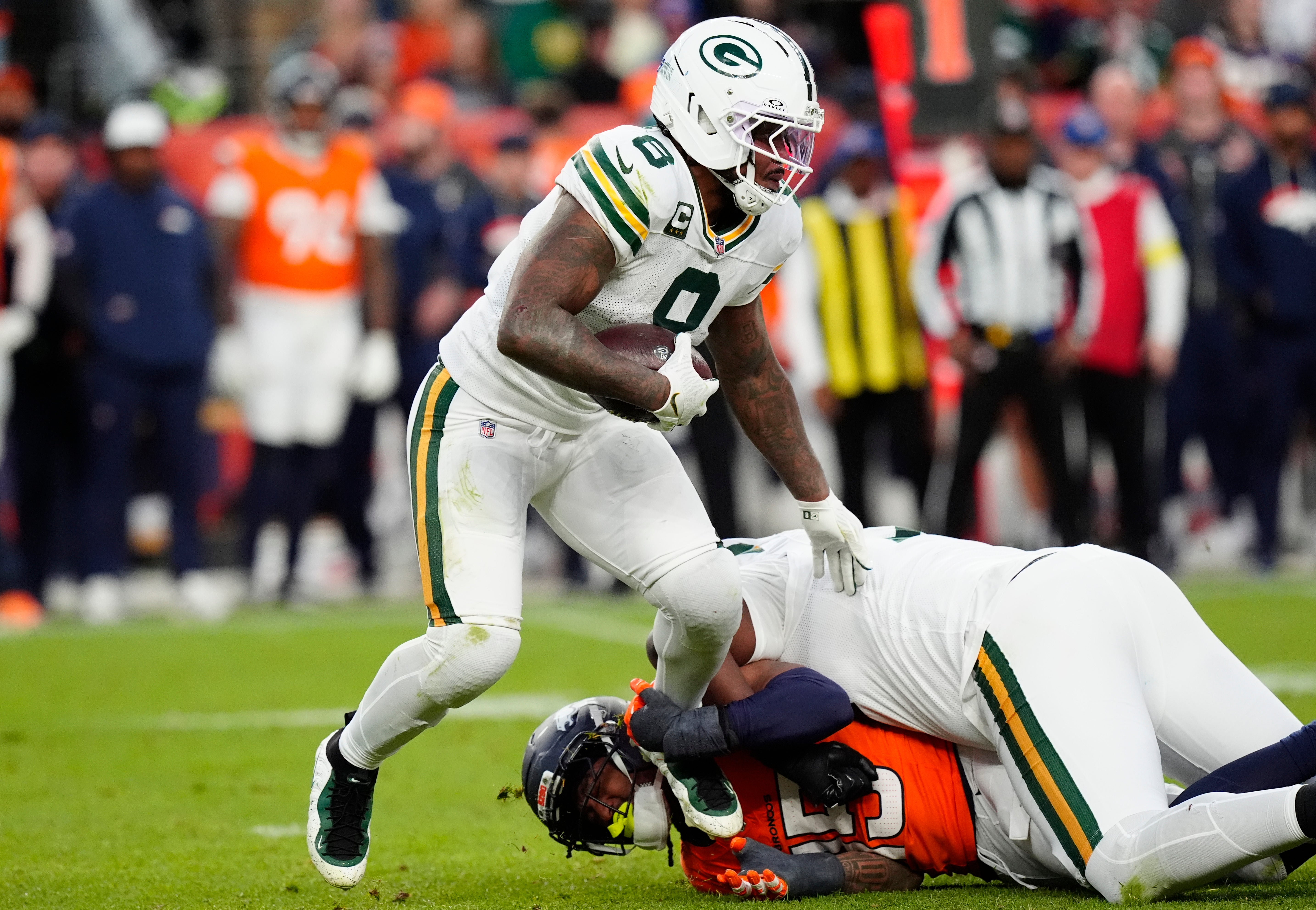 Dec 14, 2025; Denver, Colorado, USA; Green Bay Packers running back Josh Jacobs (8) runs for a gain past Denver Broncos linebacker Nik Bonitto (15) during the third quarter at Empower Field at Mile High.