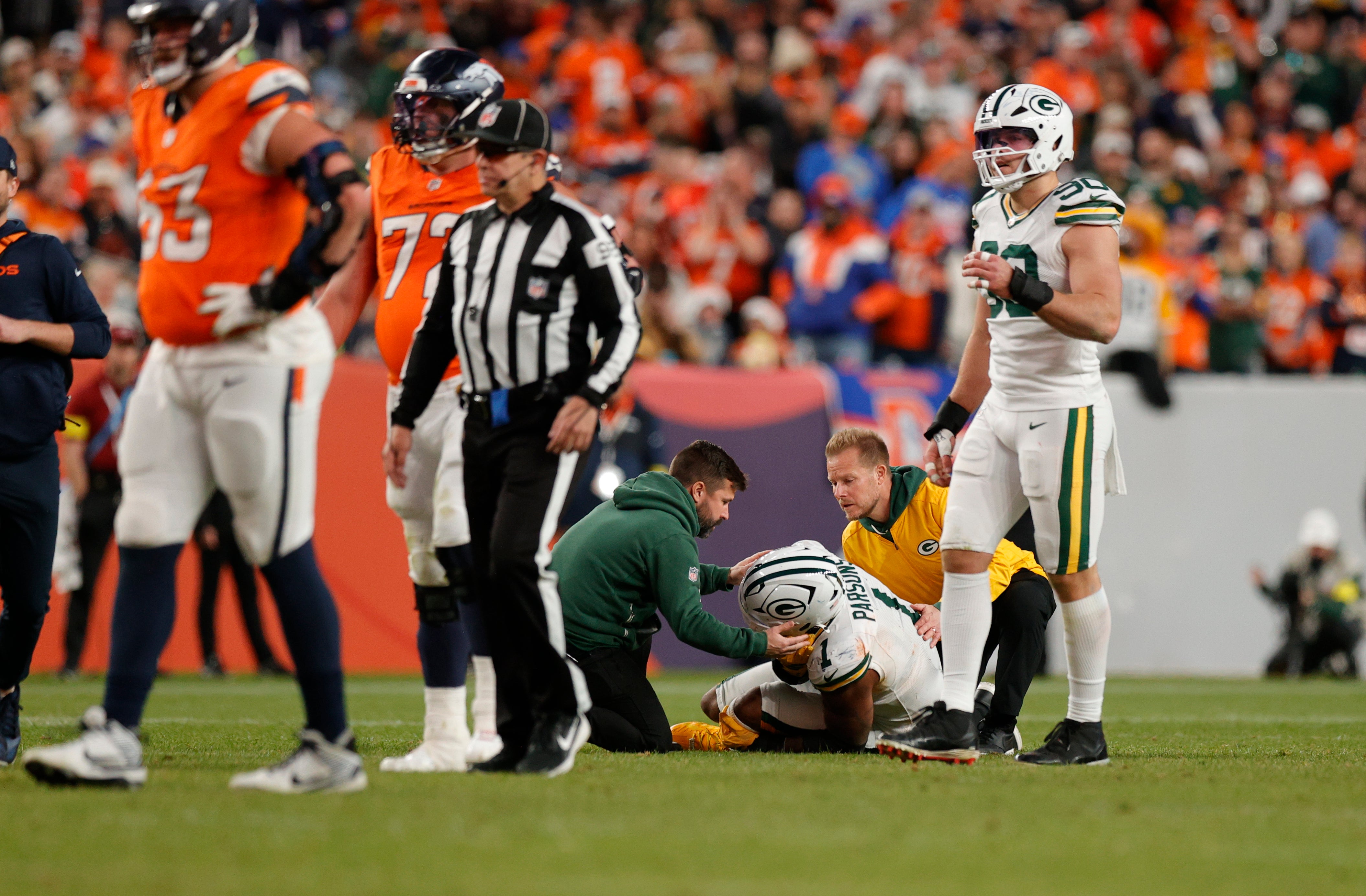 Dec 14, 2025; Denver, Colorado, USA; Medical personnel treat Green Bay Packers defensive end Micah Parsons (1) following an injury during the third quarter against the Denver Broncos at Empower Field at Mile High.