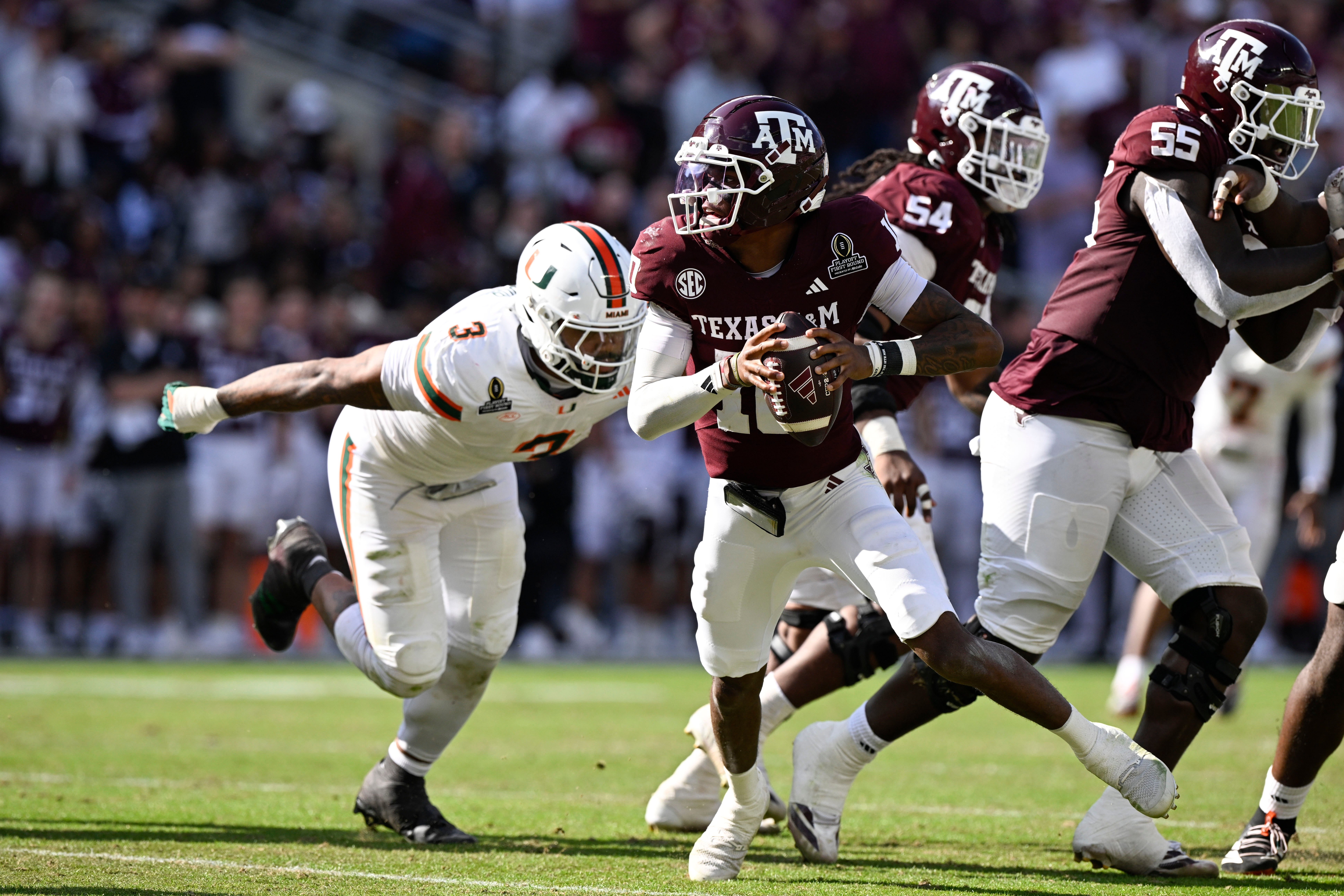 Dec 20, 2025; College Station, TX, USA; Texas A&M Aggies quarterback Marcel Reed (10) scrambles against Miami Hurricanes defensive lineman Akheem Mesidor (3) during the second half of the first round game of the CFP National Playoff at Kyle Field.