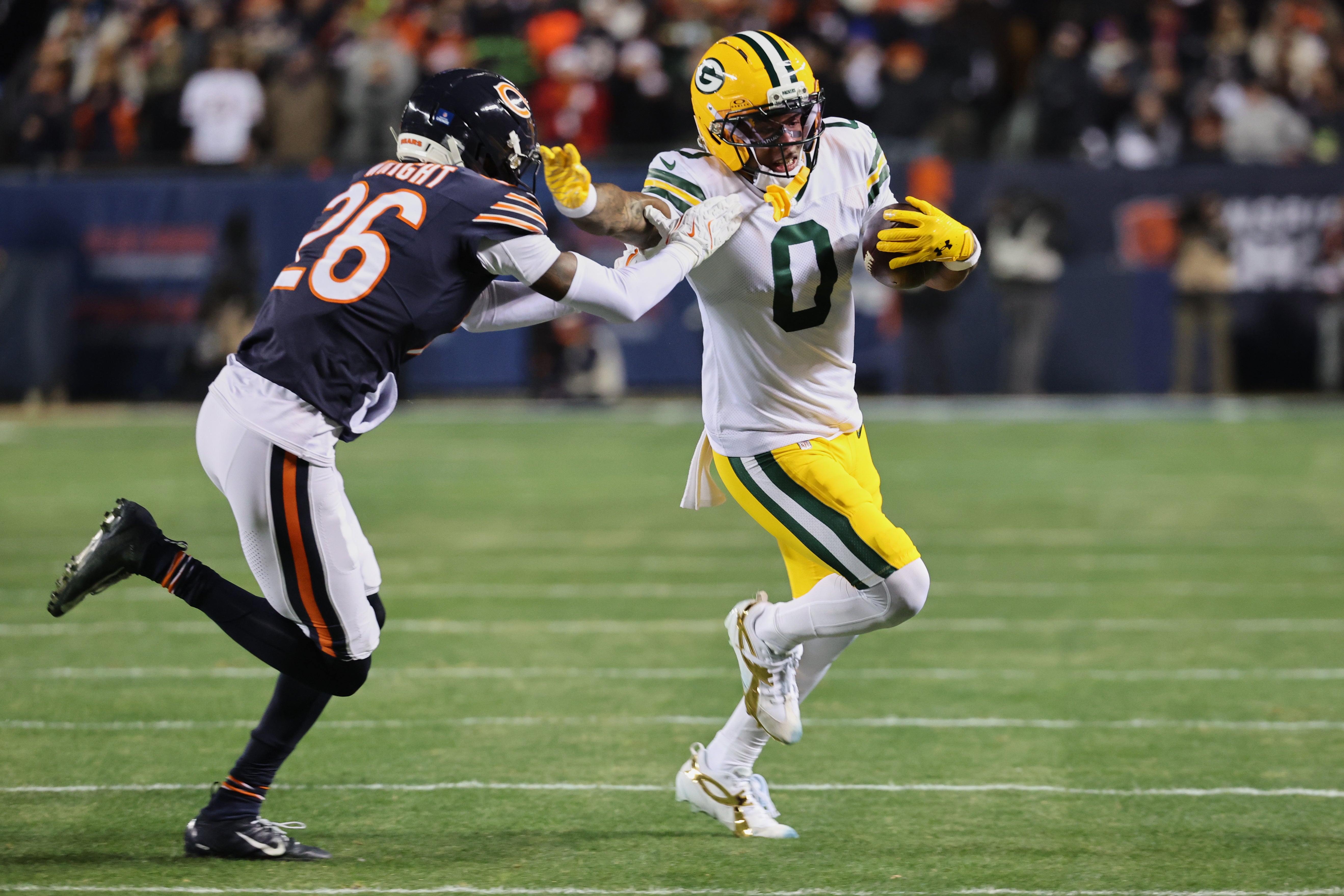 Dec 20, 2025; Chicago, Illinois, USA; Green Bay Packers wide receiver Matthew Golden (0) runs with the ball against Chicago Bears cornerback Nahshon Wright (26) during the first quarter at Soldier Field.