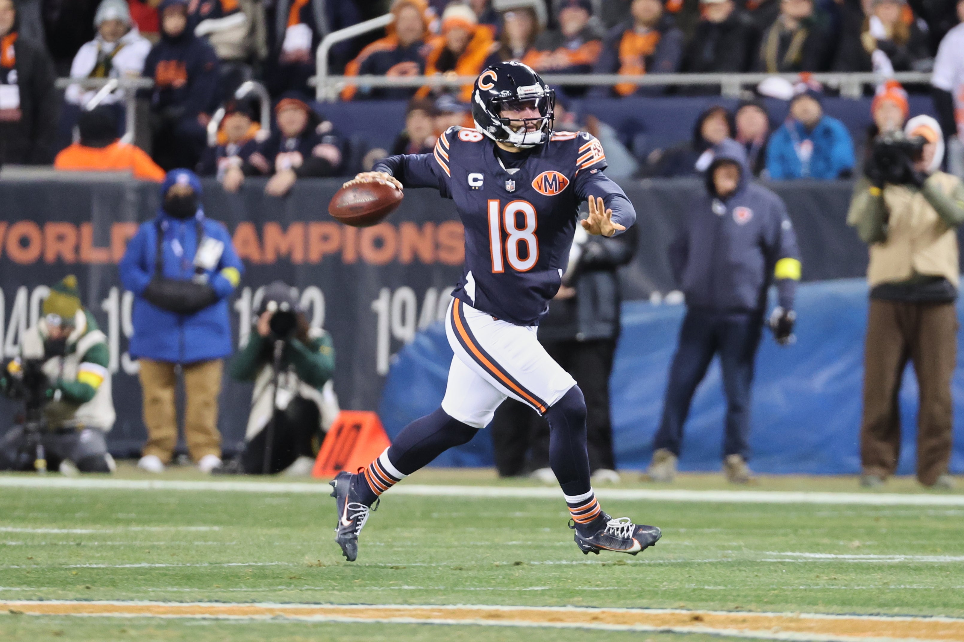 Dec 20, 2025; Chicago, Illinois, USA; Chicago Bears quarterback Caleb Williams (18) looks to throw a pass while running with the ball against the Green Bay Packers during the first quarter at Soldier Field.