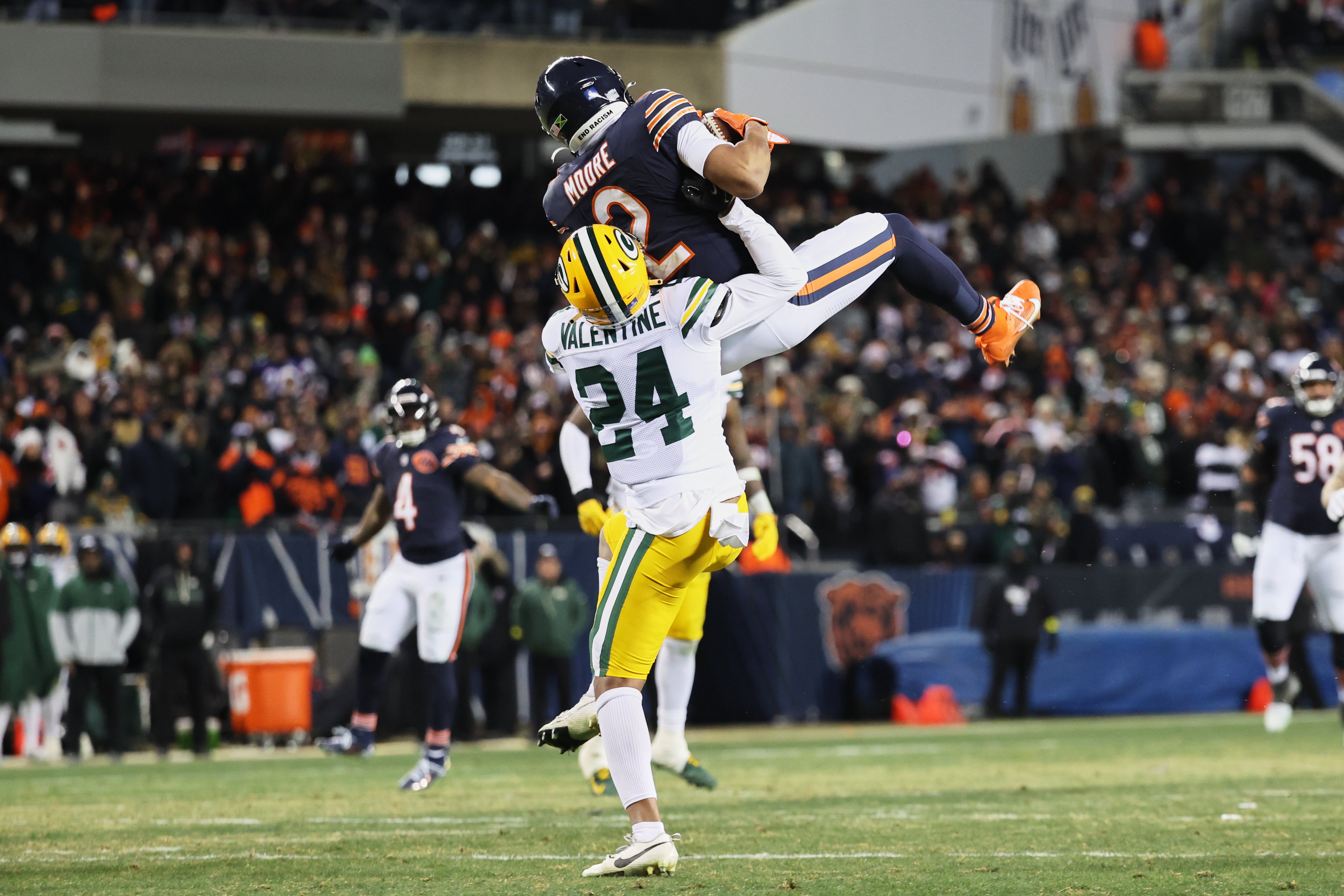 Dec 20, 2025; Chicago, Illinois, USA; Chicago Bears wide receiver DJ Moore (2) leaps to catch a pass thrown by quarterback Caleb Williams (not pictured) against Green Bay Packers cornerback Carrington Valentine (24) during overtime at Soldier Field.