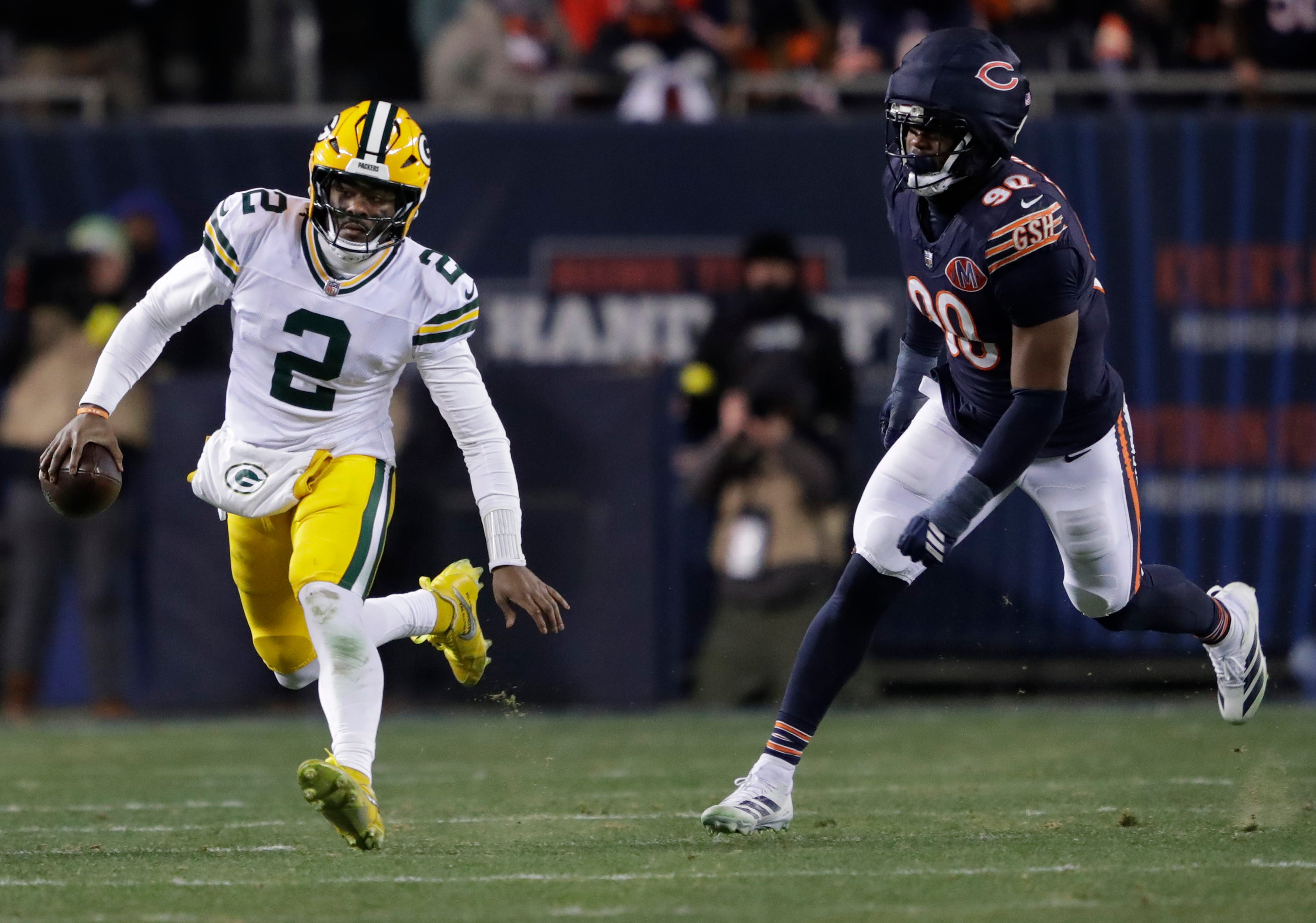 Green Bay Packers quarterback Malik Willis (2) runs for a first down against Chicago Bears defensive end Dominique Robinson (90) during their football game Saturday, December 20, 2025, at Soldier Field in Chicago, Illinois.