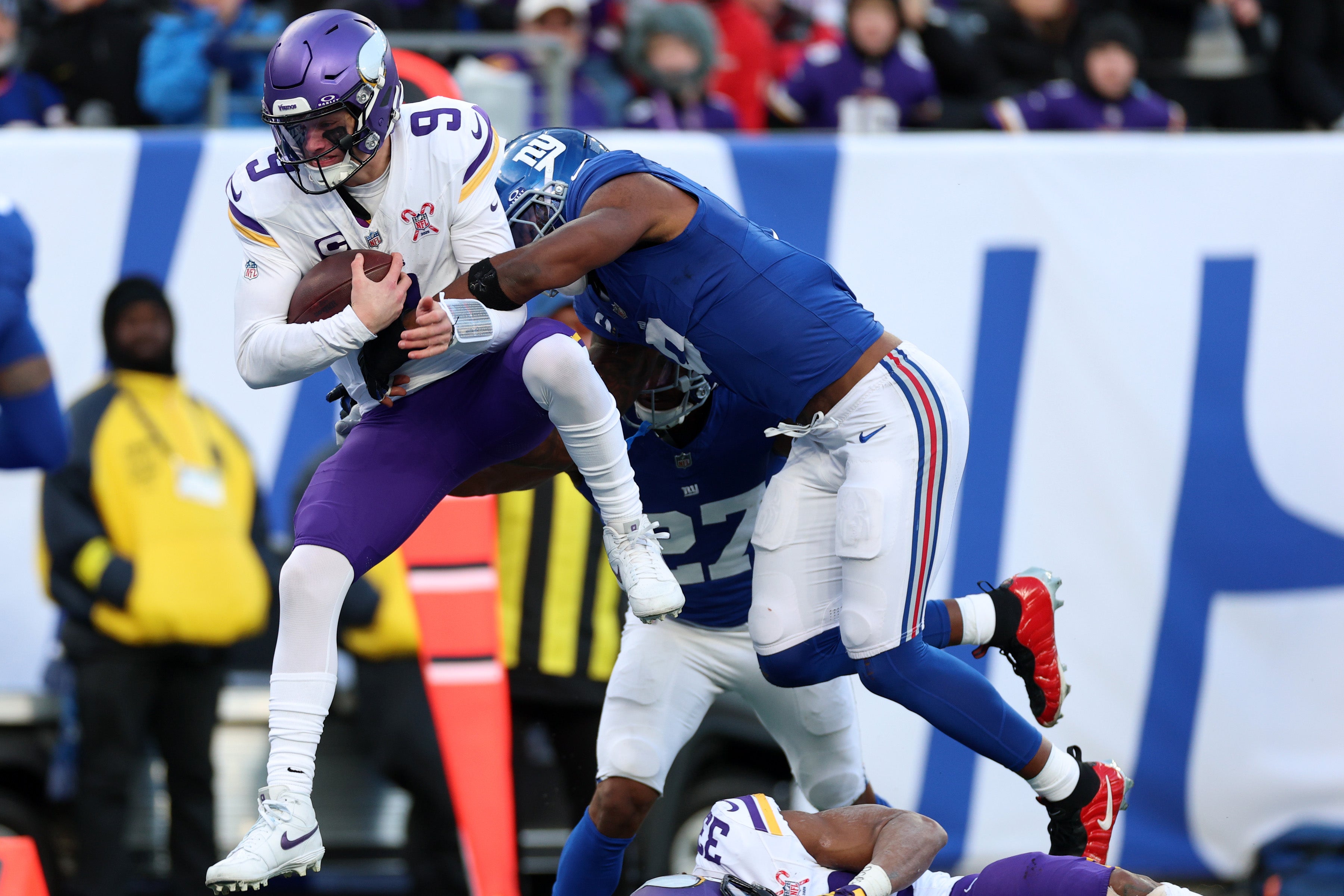 Dec 21, 2025; East Rutherford, New Jersey, USA; Minnesota Vikings quarterback J.J. McCarthy (9) leaps into the end zone against New York Giants safety Tyler Nubin (27) and linebacker Brian Burns (0) during the first half at MetLife Stadium.