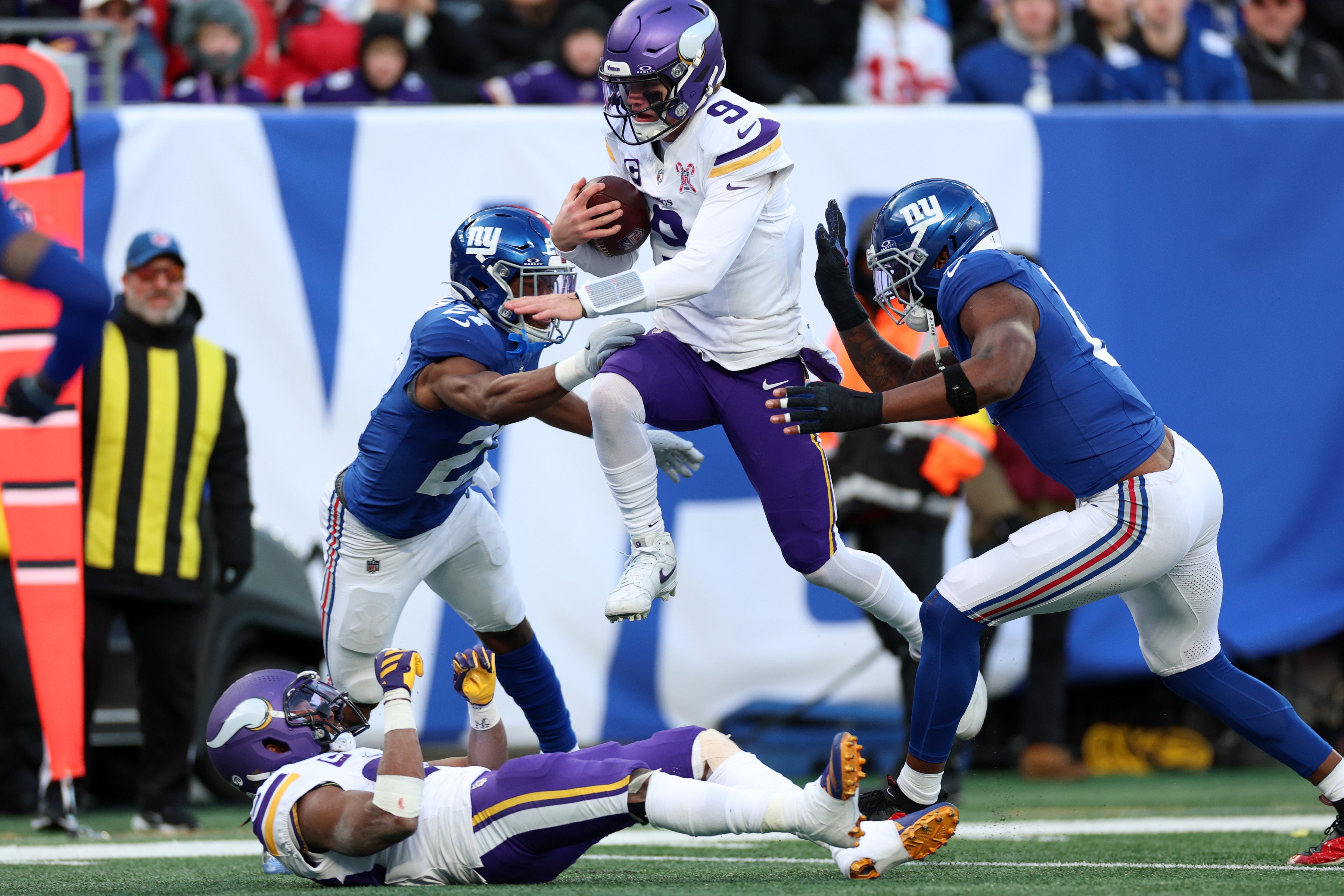 Dec 21, 2025; East Rutherford, New Jersey, USA; Minnesota Vikings quarterback J.J. McCarthy (9) leaps into the end zone against New York Giants safety Tyler Nubin (27) and linebacker Brian Burns (0) during the first half at MetLife Stadium.