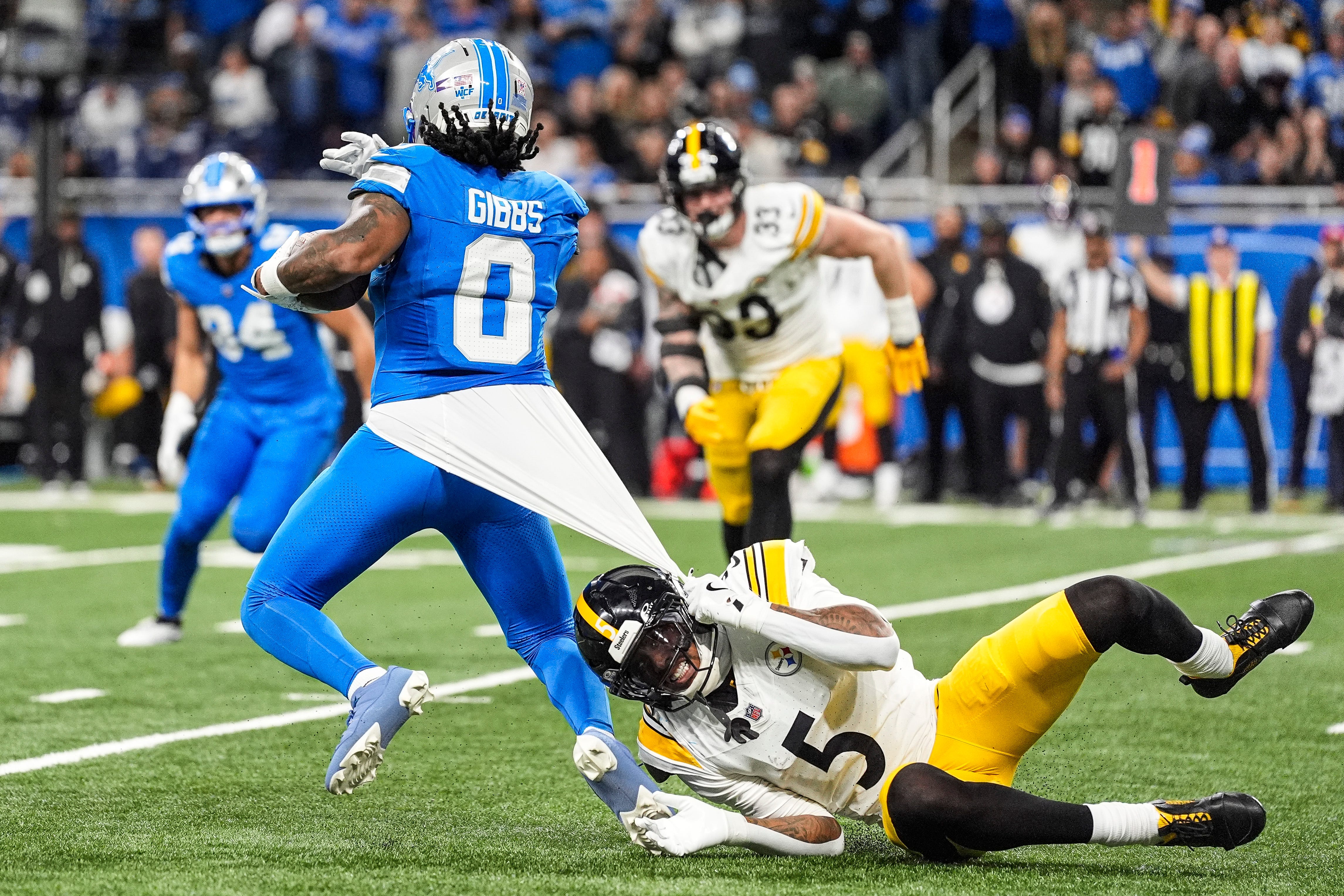 Pittsburgh Steelers cornerback Jalen Ramsey (5) tackles Detroit Lions running back Jahmyr Gibbs (0) during the second half at Ford Field in Detroit on Sunday, Dec. 21, 2025.