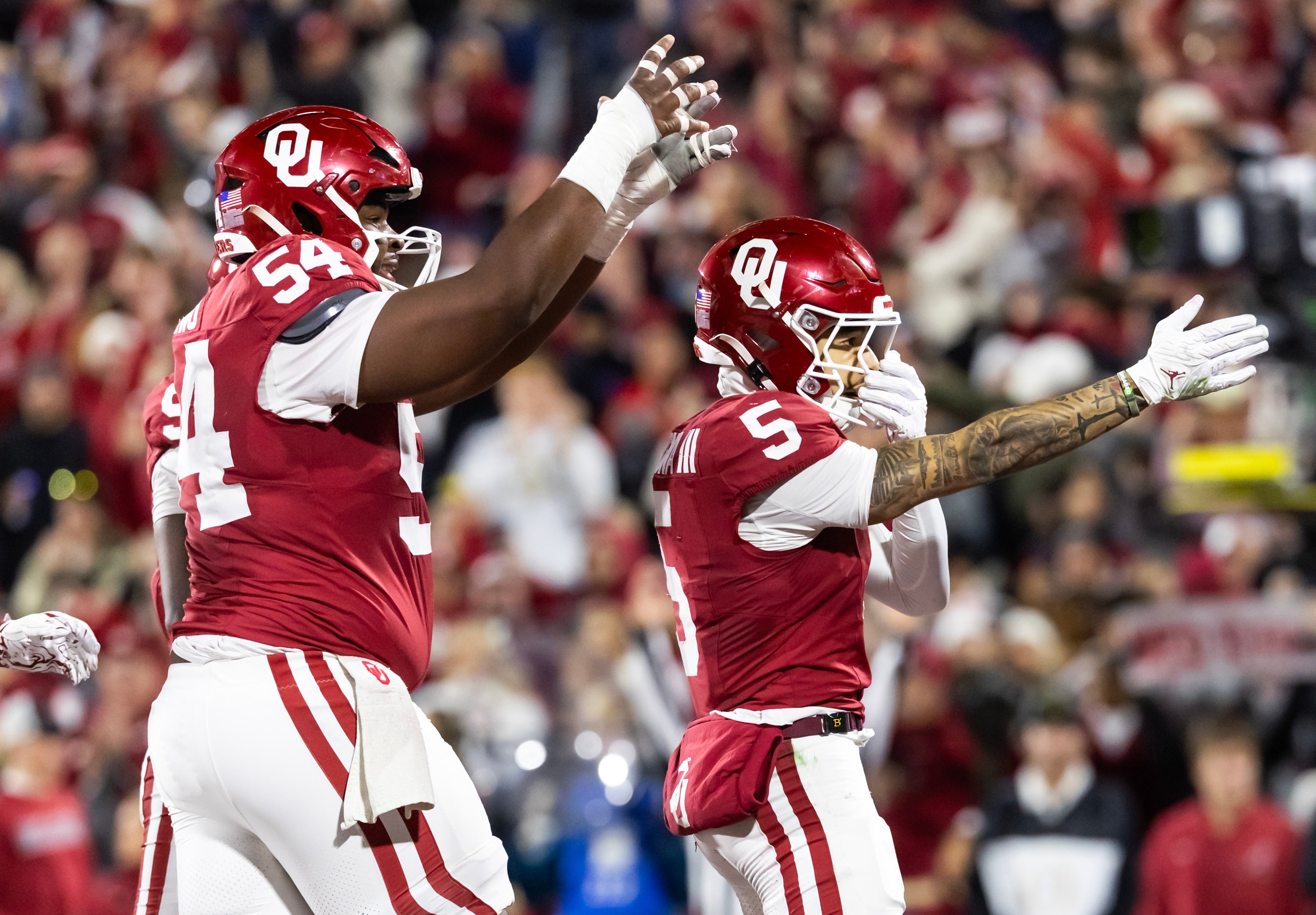 Dec 19, 2025; Norman, OK, USA; Oklahoma Sooners wide receiver Isaiah Sategna III (5) celebrates with offensive lineman Febechi Nwaiwu (54) after scoring a touchdown against the Alabama Crimson Tide during the CFP National Playoff First Round at Gaylord Family Oklahoma Memorial Stadium.