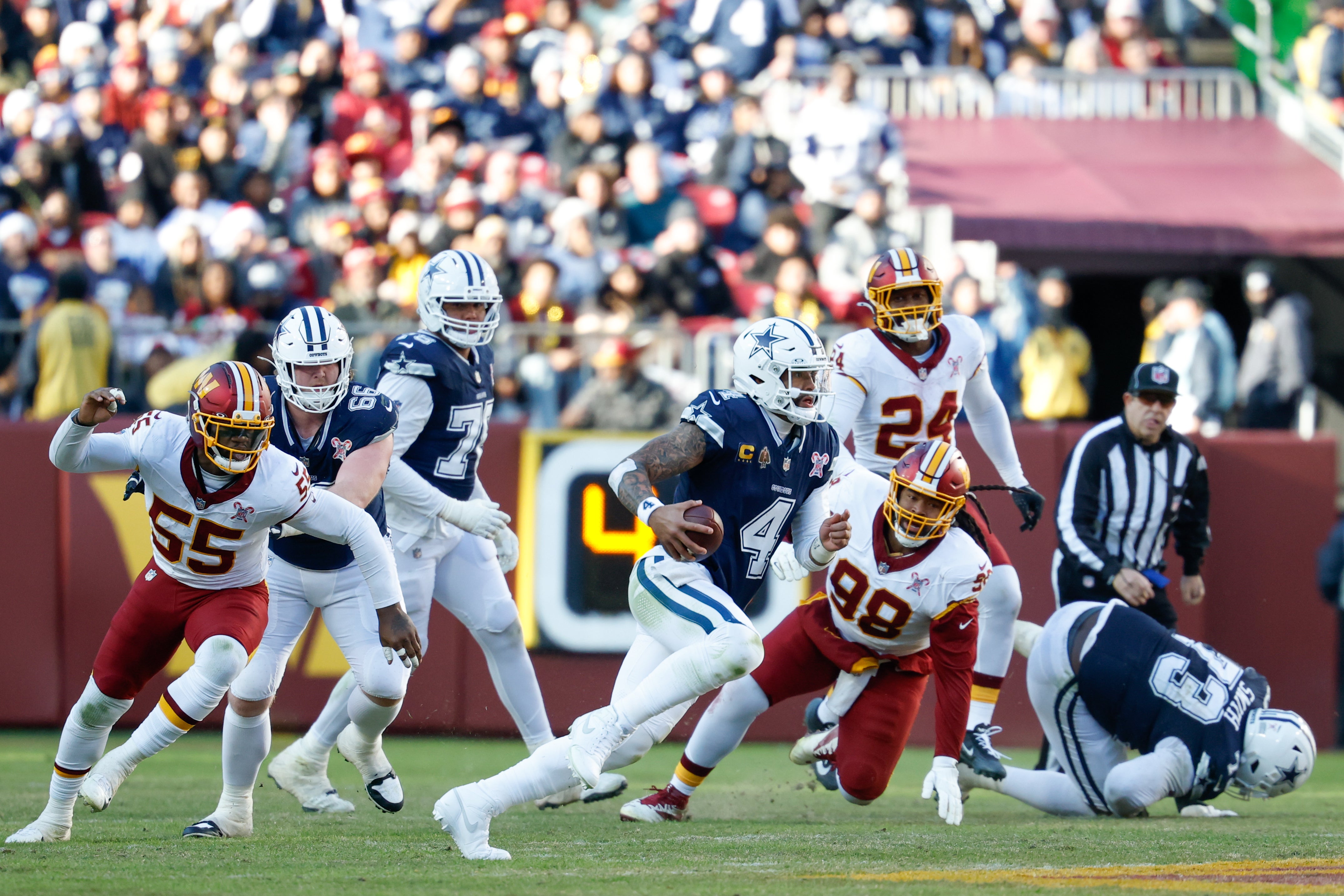 Dec 25, 2025; Landover, Maryland, USA; Dallas Cowboys quarterback Dak Prescott (4) scrambles with the ball against the Washington Commanders in the second quarter at Northwest Stadium.