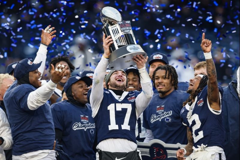 Dec 27, 2025; Bronx, NY, USA; Penn State Nittany Lions quarterback Ethan Grunkemeyer (17) and teammates celebrate with the George M. Steinbrenner Trophy after defeating the Clemson Tigers in the 2025 Pinstripe Bowl at Yankee Stadium. Mandatory Credit: Vincent Carchietta-Imagn Images