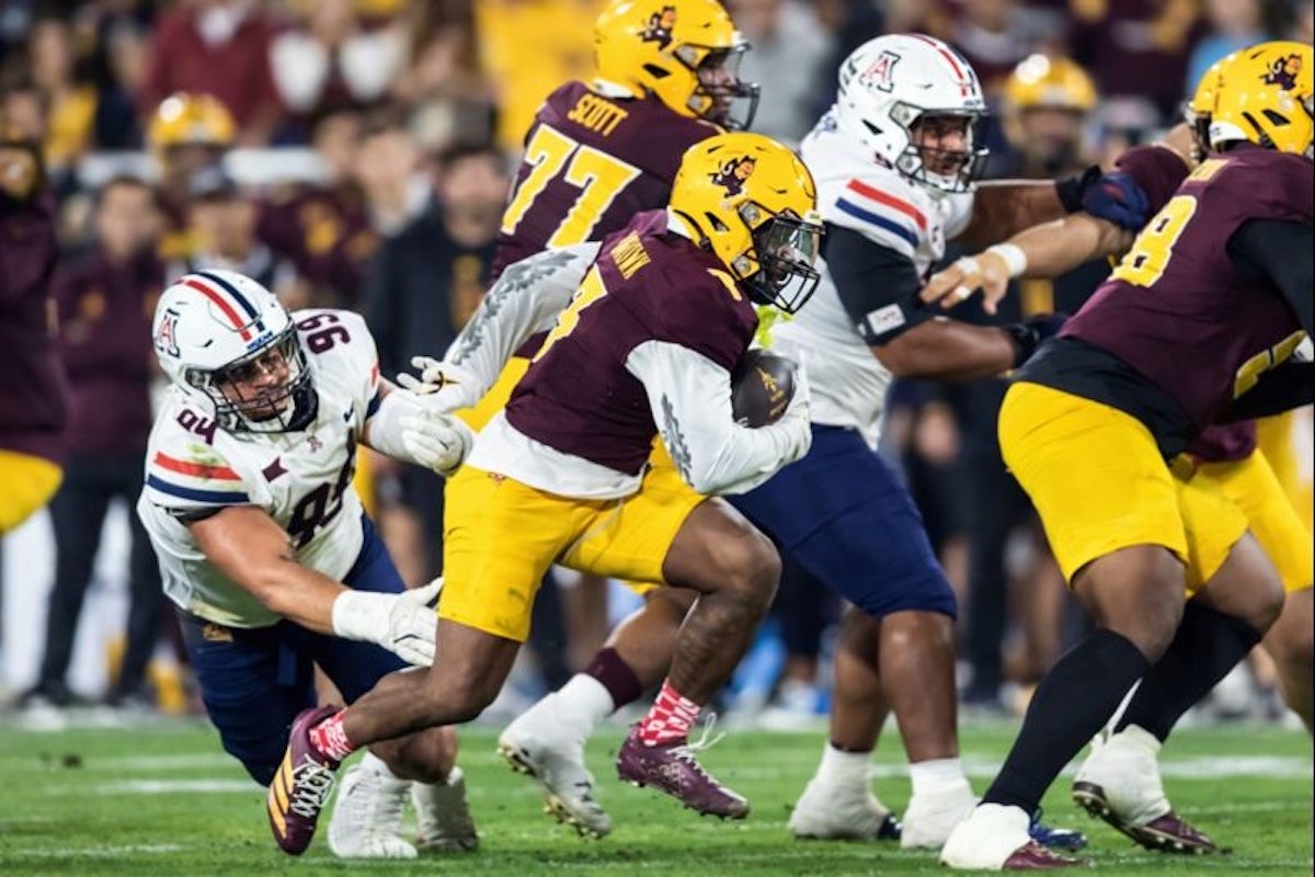 Nov 28, 2025; Tempe, Arizona, USA; Arizona State Sun Devils running back Raleek Brown (3) runs the ball against Arizona Wildcats defensive lineman Mays Pese (99) in the first half during the 99th Territorial Cup at Mountain America Stadium. Mandatory Credit: Mark J. Rebilas-Imagn Images